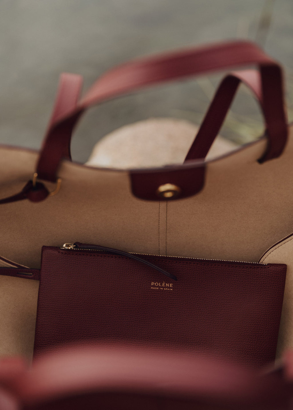 Bolso polene Cyme en piel granulada color cereza negra, con asa ajustable y detalles elegantes.