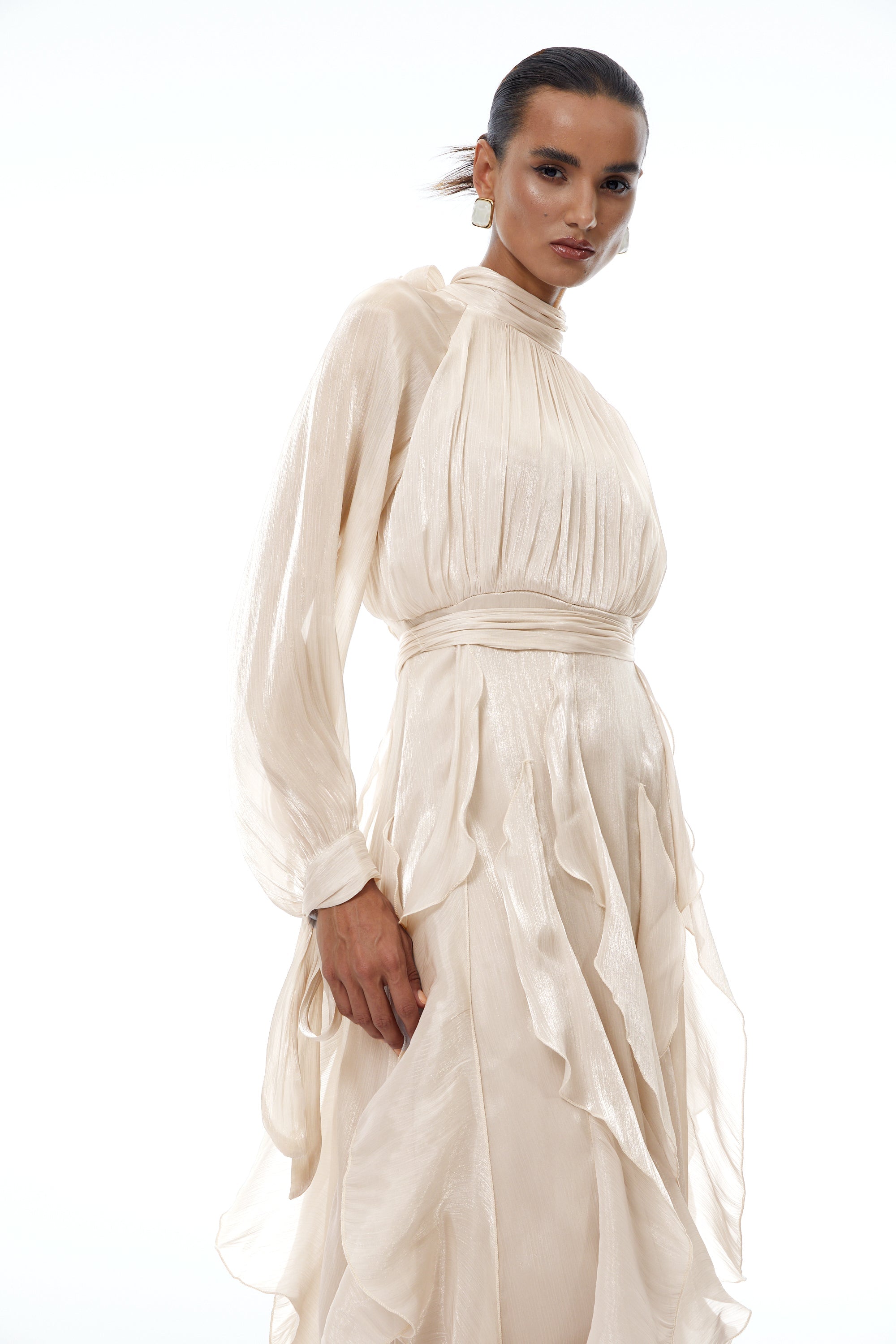Vestido largo Zélie Neutral con plisados y volantes, acabado brillante y elegante, diseñado para ocasiones especiales.