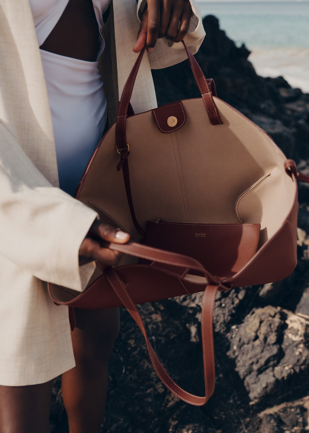 Bolso de mano Polène Cyme en piel granulada color coñac, diseño elegante y texturizado.