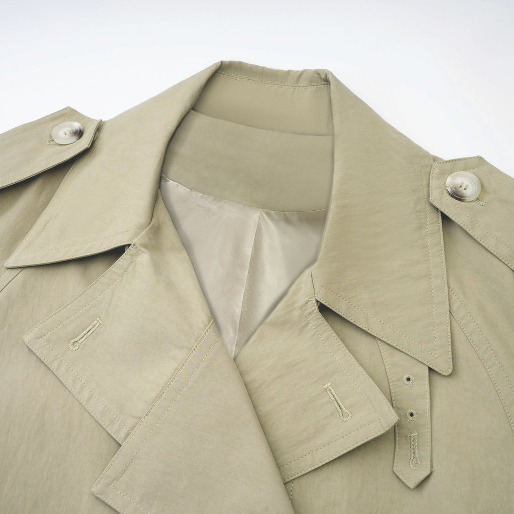 Abrigo trench con cinturón de la marca MRNewyork, color beige, con solapas y bolsillos frontales, vista frontal.