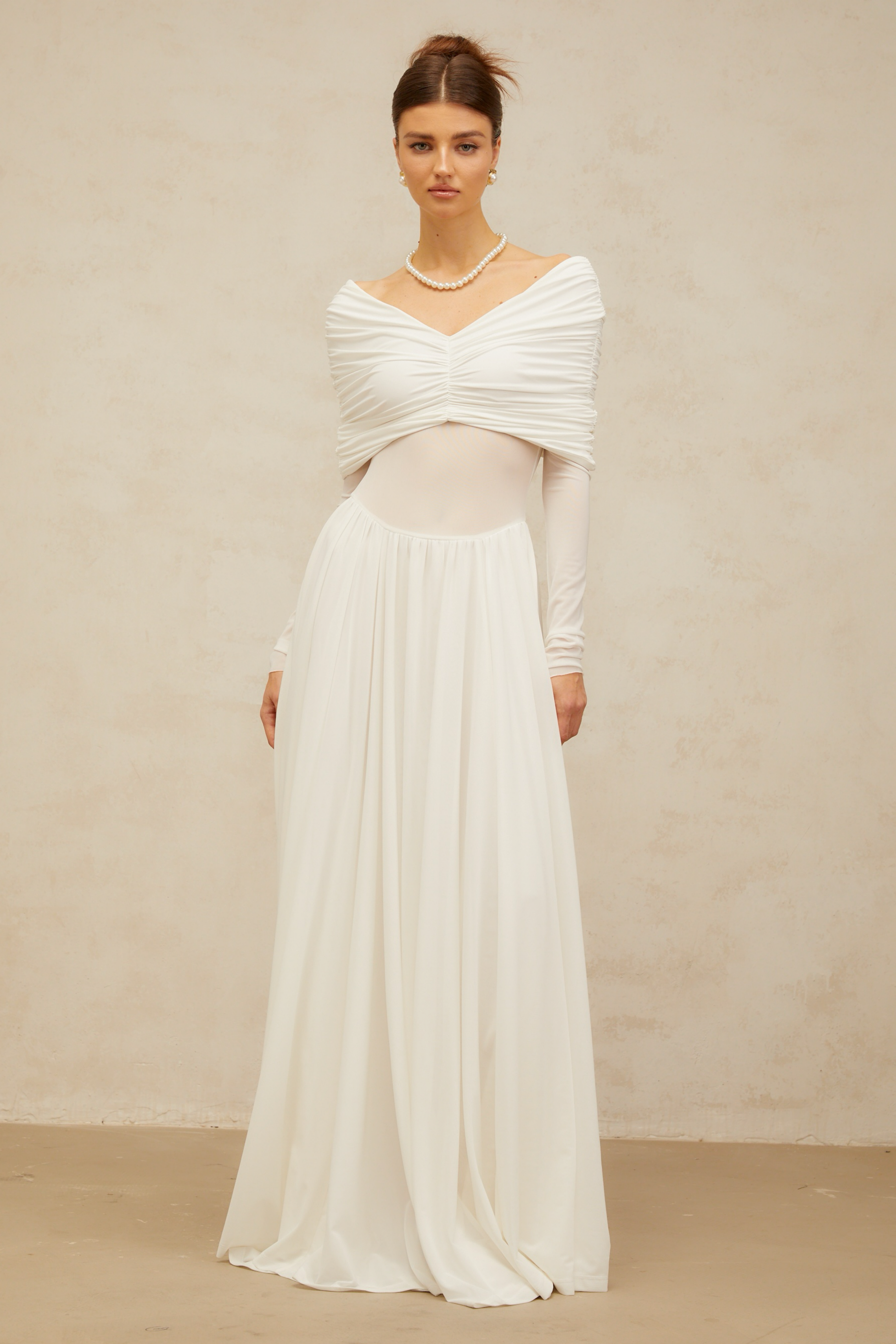 Vestido largo blanco Vérane con drapeado y ruched, estilo maxi, ideal para ocasiones elegantes, en imagen con detalles de tela fluida.