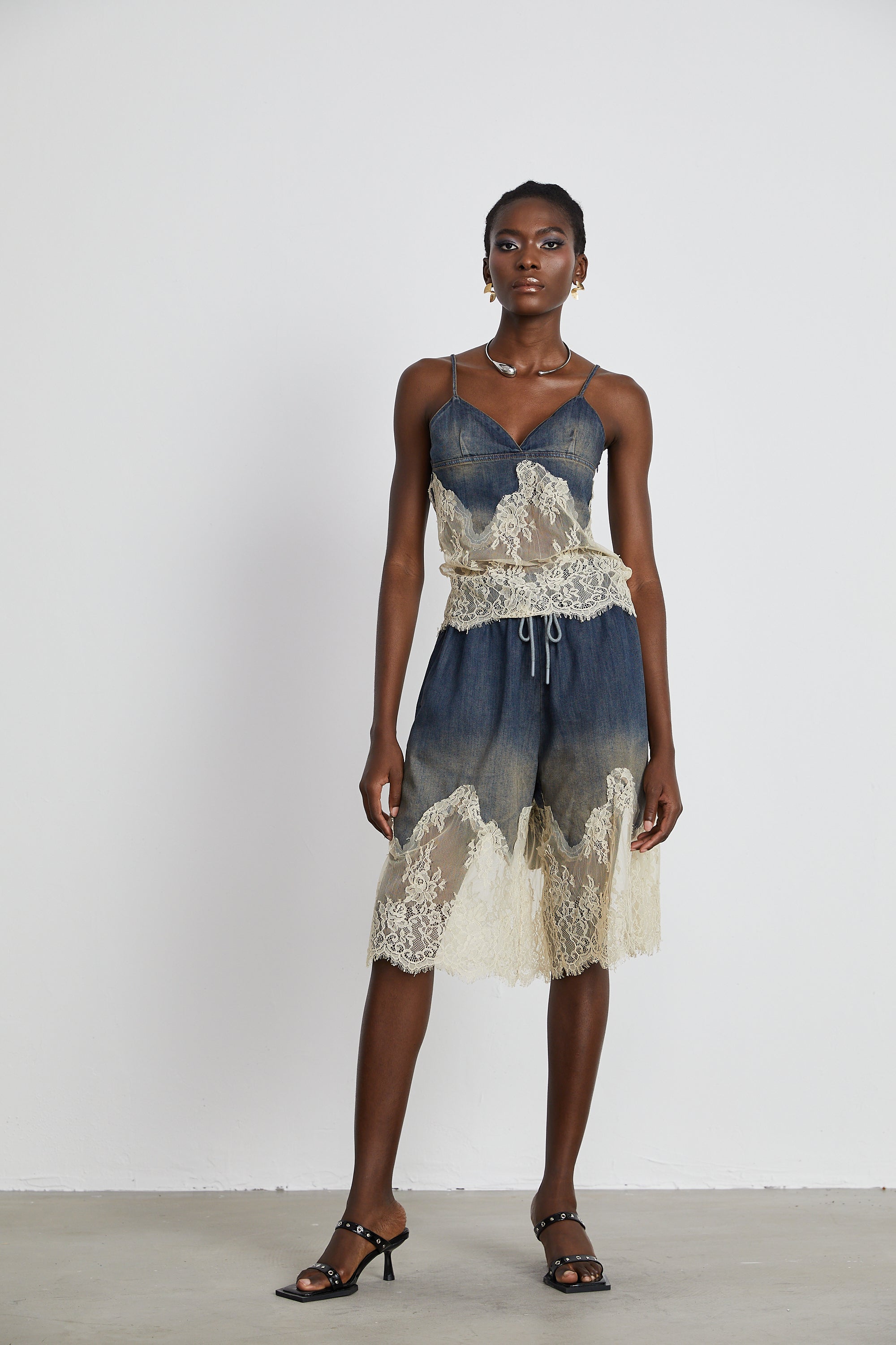 Conjunto de mezclilla Sylvie con top y shorts a juego con detalles de encaje, en color azul, en un fondo blanco.
