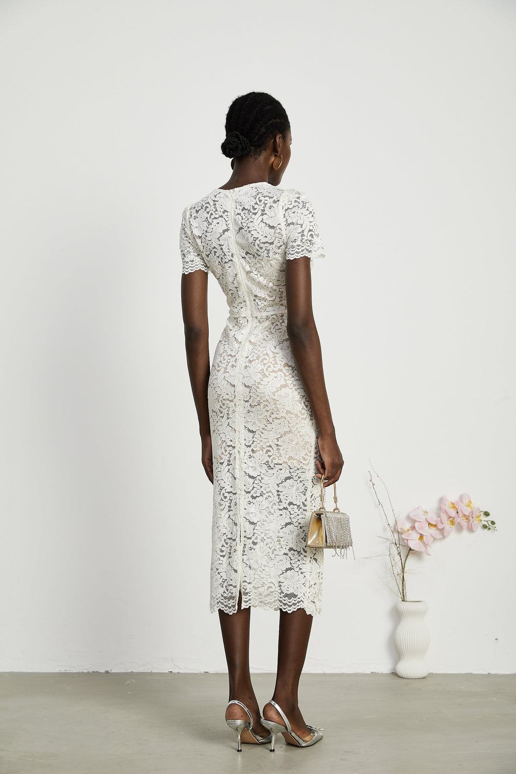 Vestido midi de encaje con bordados Kalena, elegante y femenino, en color claro con detalles decorativos en la parte superior.