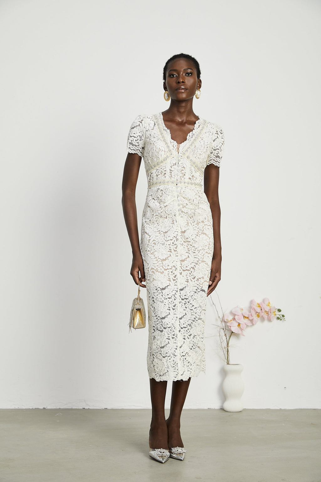 Vestido midi de encaje con bordados Kalena, elegante y ajustado, en color oscuro con detalles ornamentales.