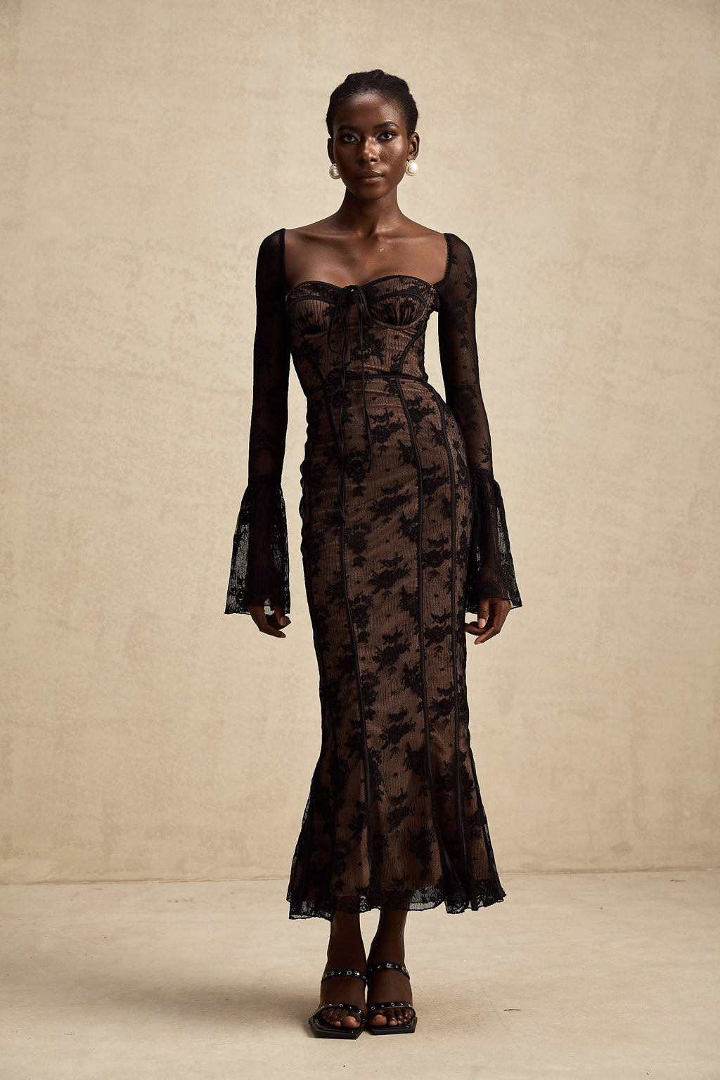 Vestido largo de encaje negro Marlene de corte globo, con falda acampanada y detalles elegantes para ocasiones especiales.