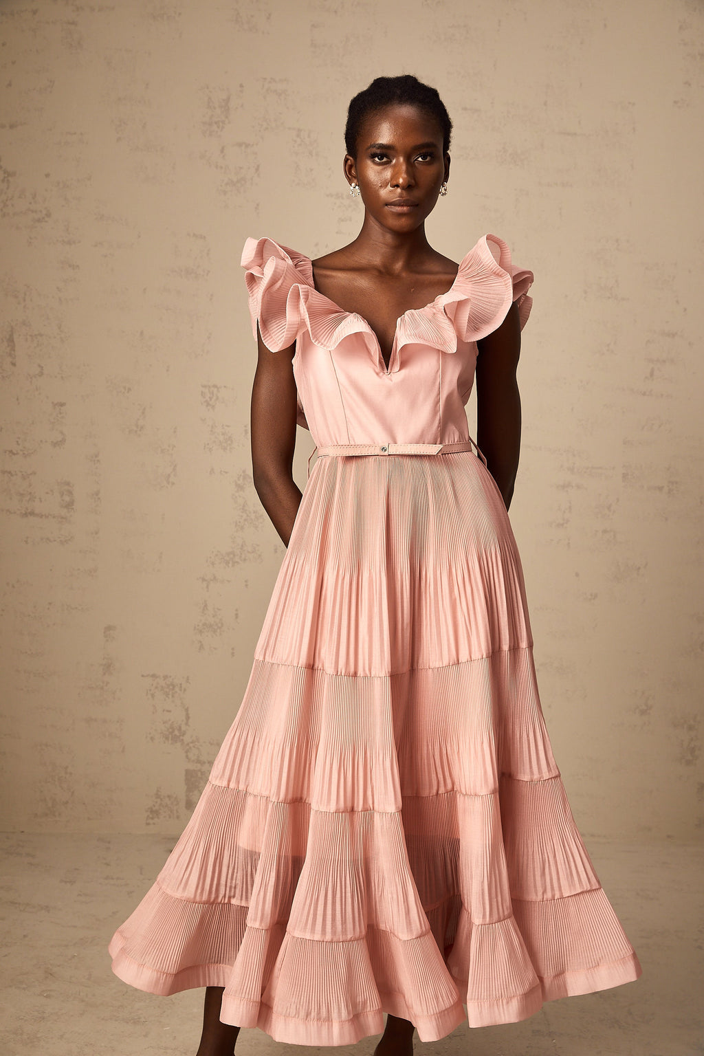 Vestido midi plisado en coral rosado de Valentina con detalles frill, diseño elegante y femenino, ideal para ocasiones especiales.