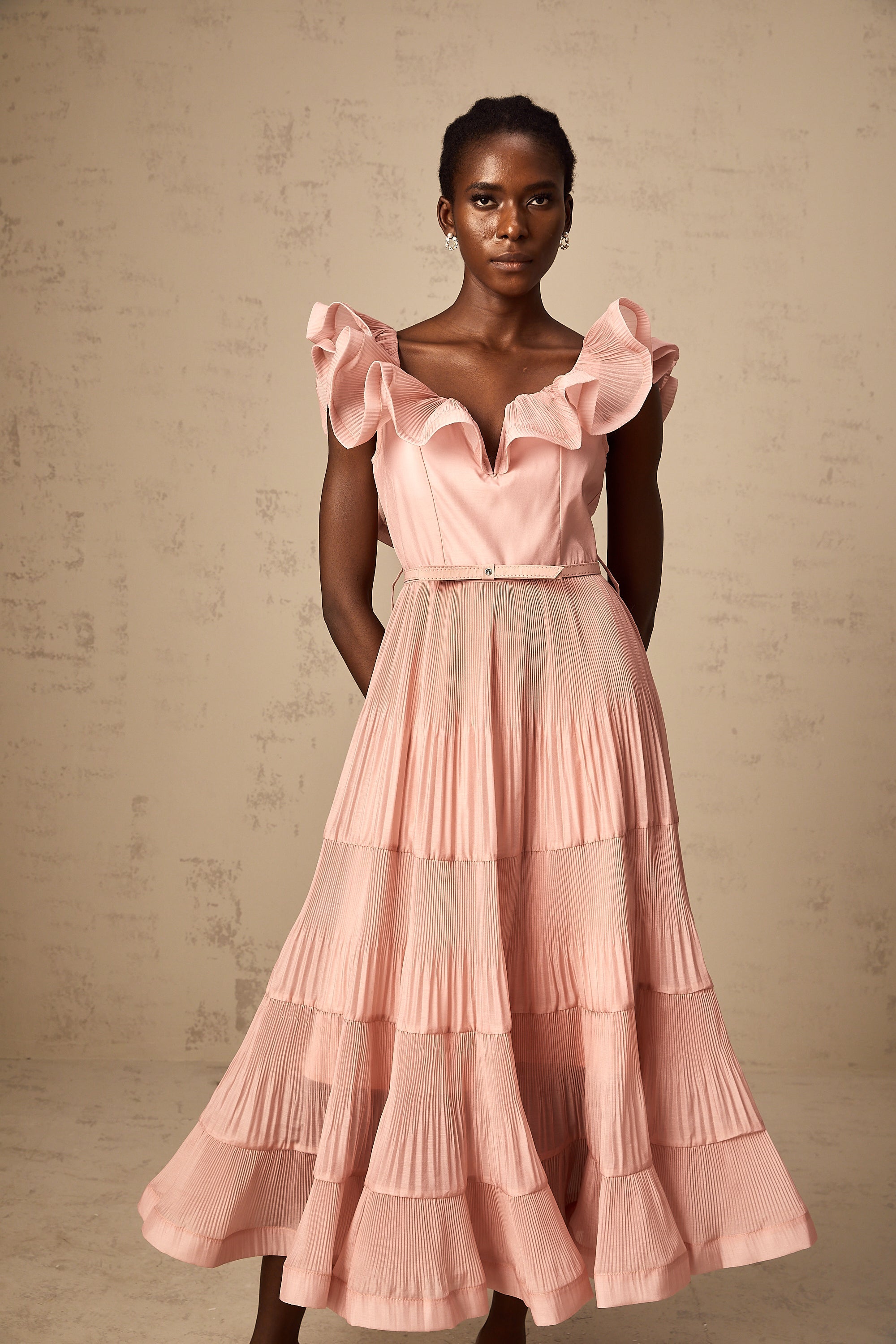 Vestido midi plisado en coral rosado de Valentina con detalles frill, diseño elegante y femenino, ideal para ocasiones especiales.