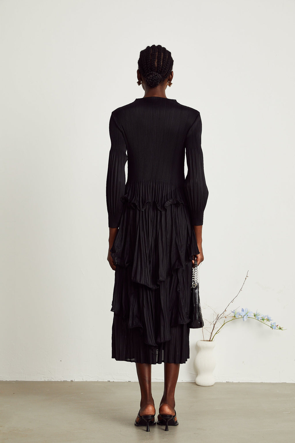Vestido midi plisado con capas negras de MRMelbourne, diseño elegante y moderno con detalles en la falda.