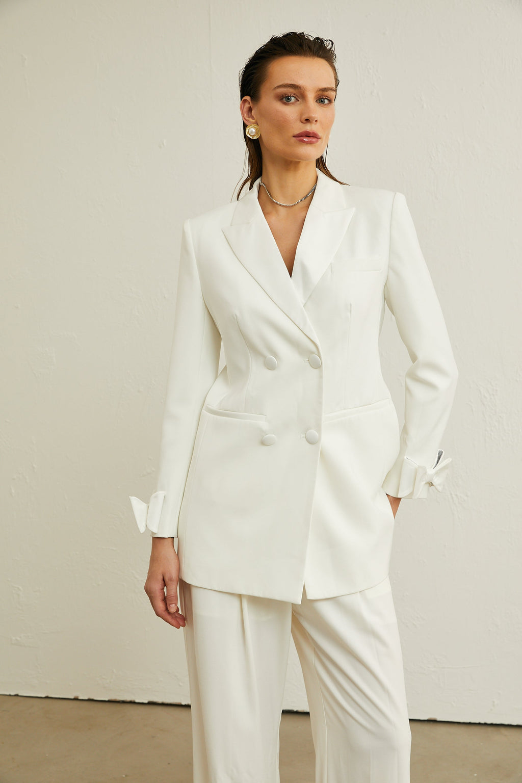 Chaqueta de lana blanca Margaux con lazo decorativo, diseñada por Final Sale, vista en detalle sobre fondo neutro.