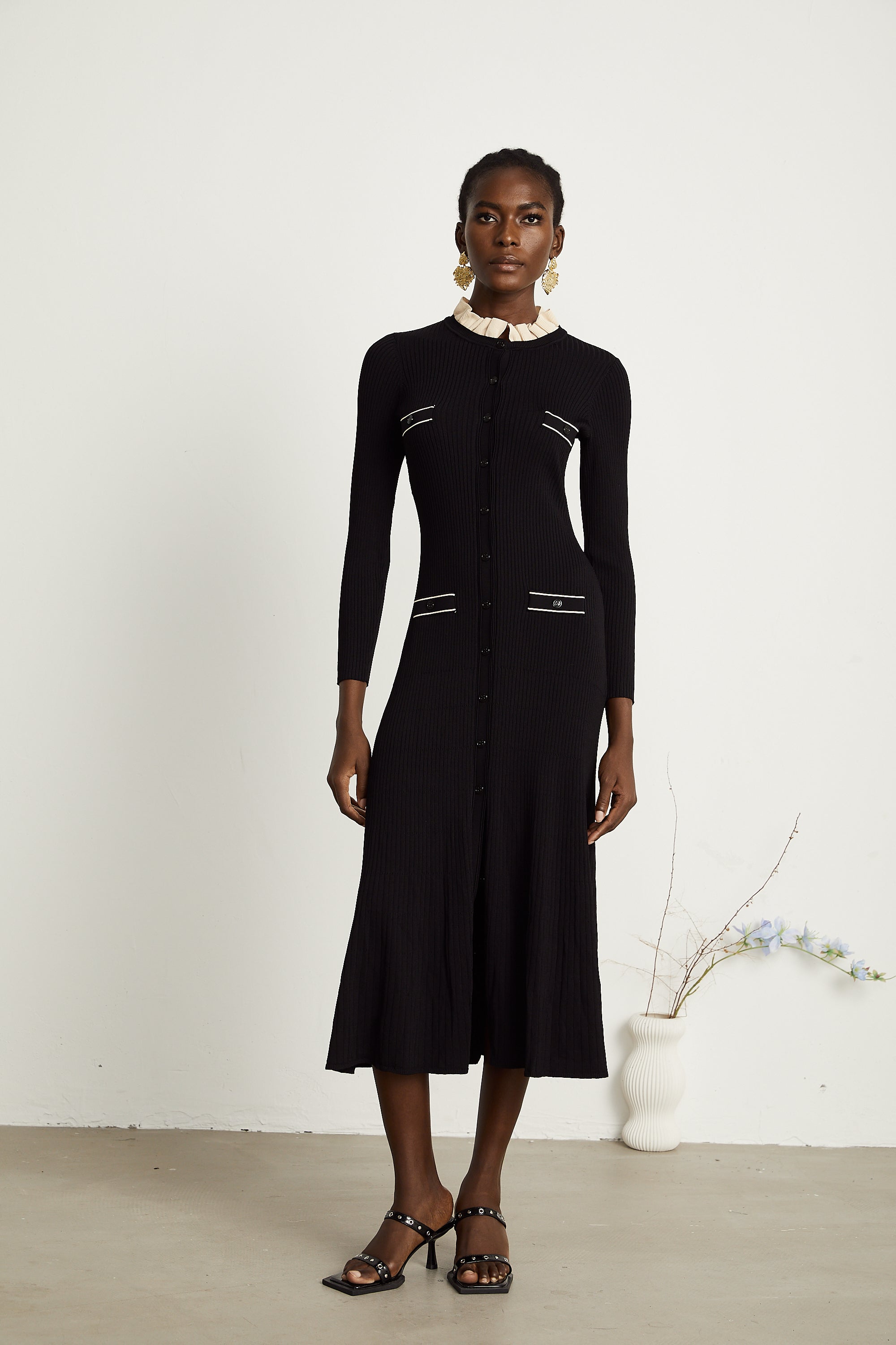 Vestido midi negro de punto de cuello volante de la marca Final Sale, con diseño ajustado y detalles elegantes.