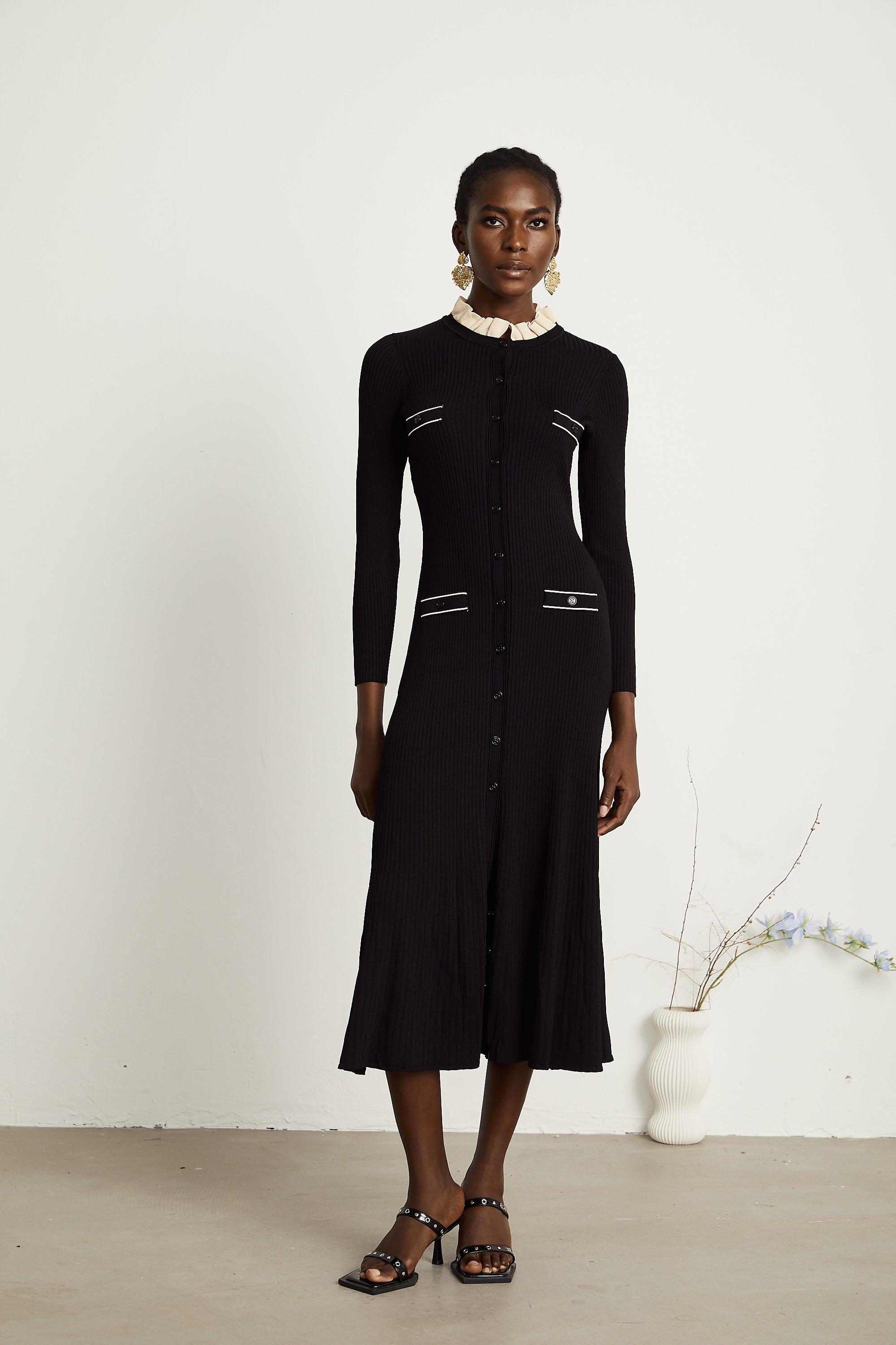 Vestido midi negro de punto con cuello fruncido de la marca Final Sale, con diseño elegante y detalles de volantes en el cuello.