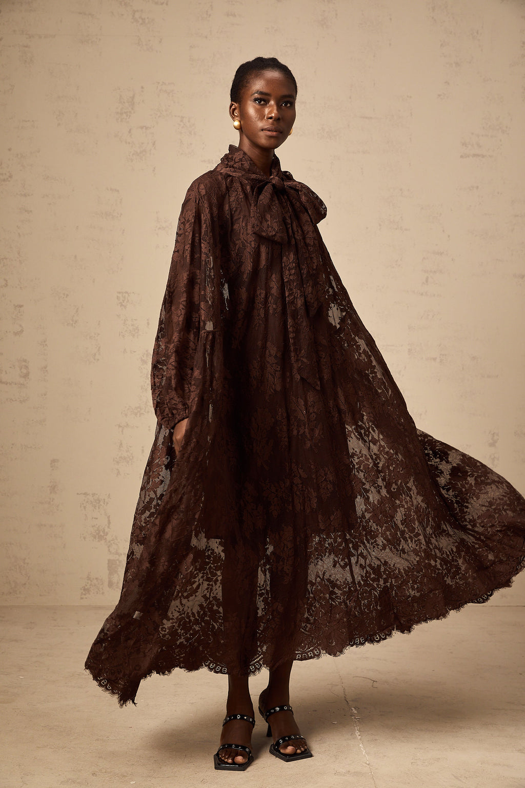 Vestido midi con vuelo en encaje chantilly marrón Sylvie, estilo femenino y elegante, con diseño ajustado en la parte superior.