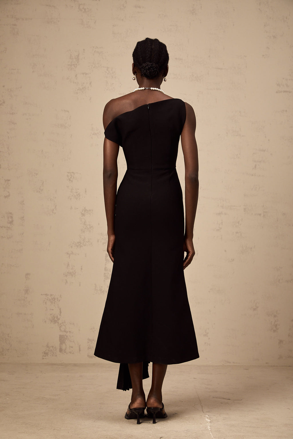 Vestido midi asimétrico negro Laurine de Final Sale, con drapeado elegante y diseño moderno.
