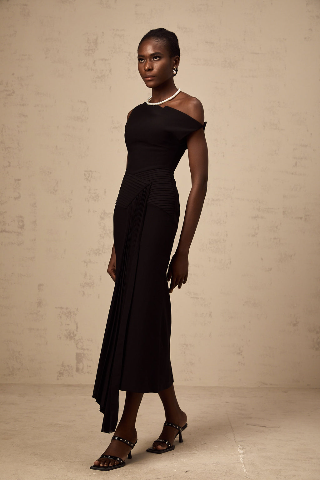 Vestido midi asimétrico negro Laurine de marca Final Sale, con drapeado elegante y estilo moderno.