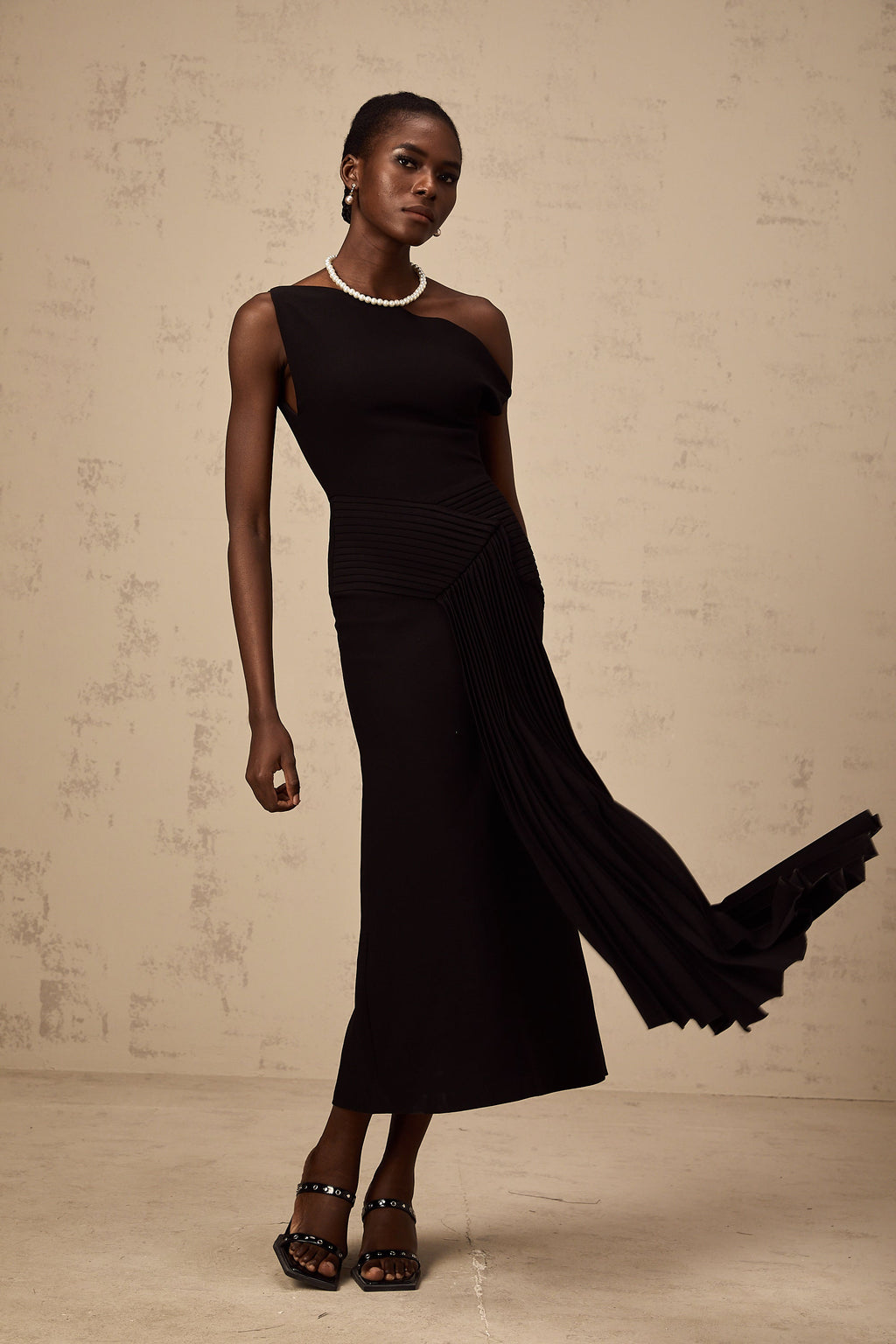 Vestido midi asimétrico negro Laurine de Final Sale, con drapeado elegante y diseño moderno.