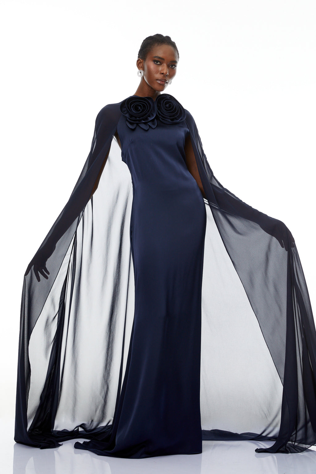 Mujer con vestido largo azul Riccardo Blue 3D Petal Cape Maxi Gown de MRMelbourne, con detalles en capas y diseño elegante.