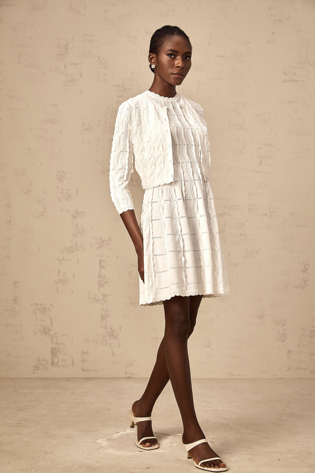 Cardigan de punto blanco Esmée con volantes y diseño rizado, ideal para un estilo elegante y casual.