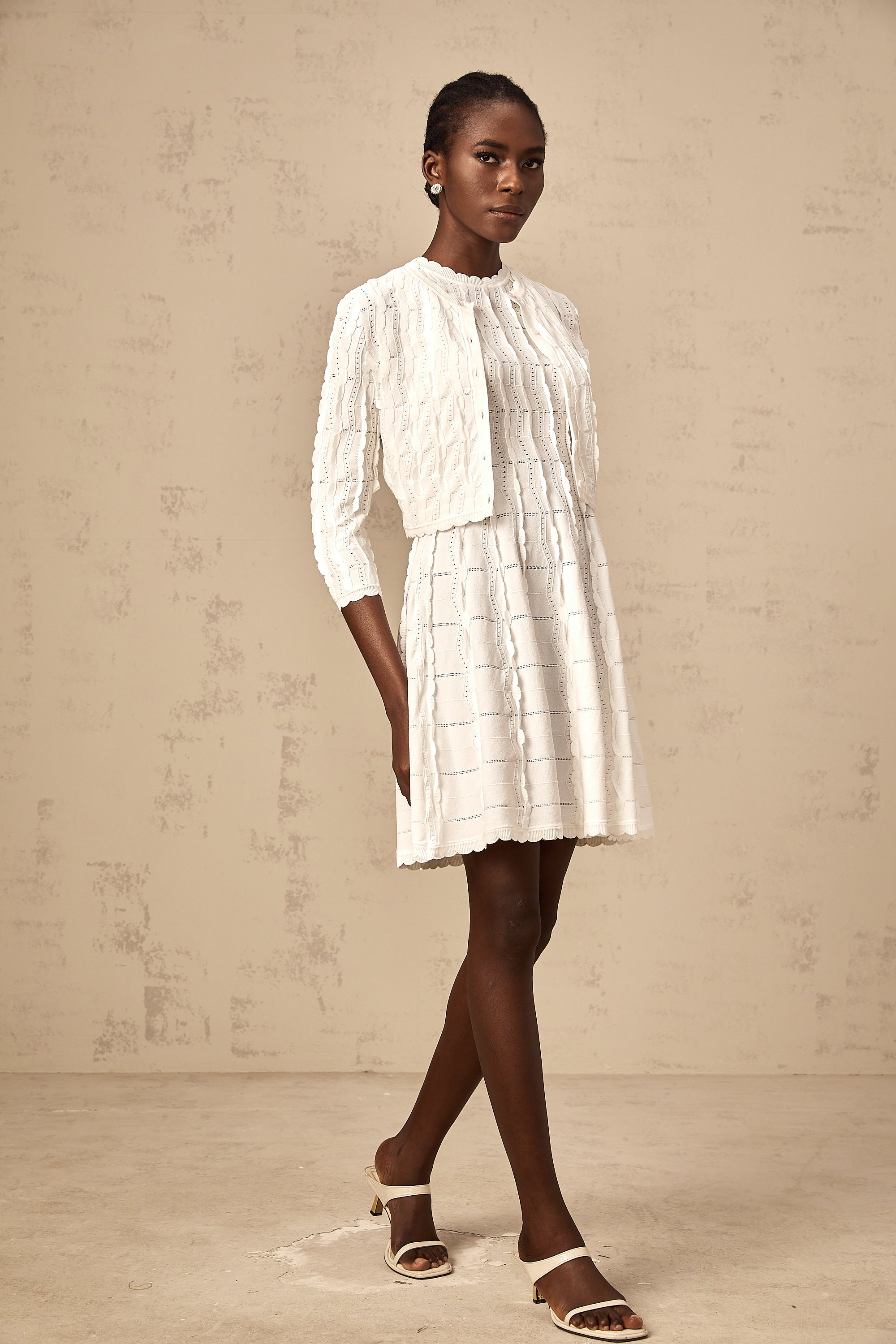 Cardigan de punto blanco Esmée con volantes y diseño rizado, ideal para un estilo elegante y casual.