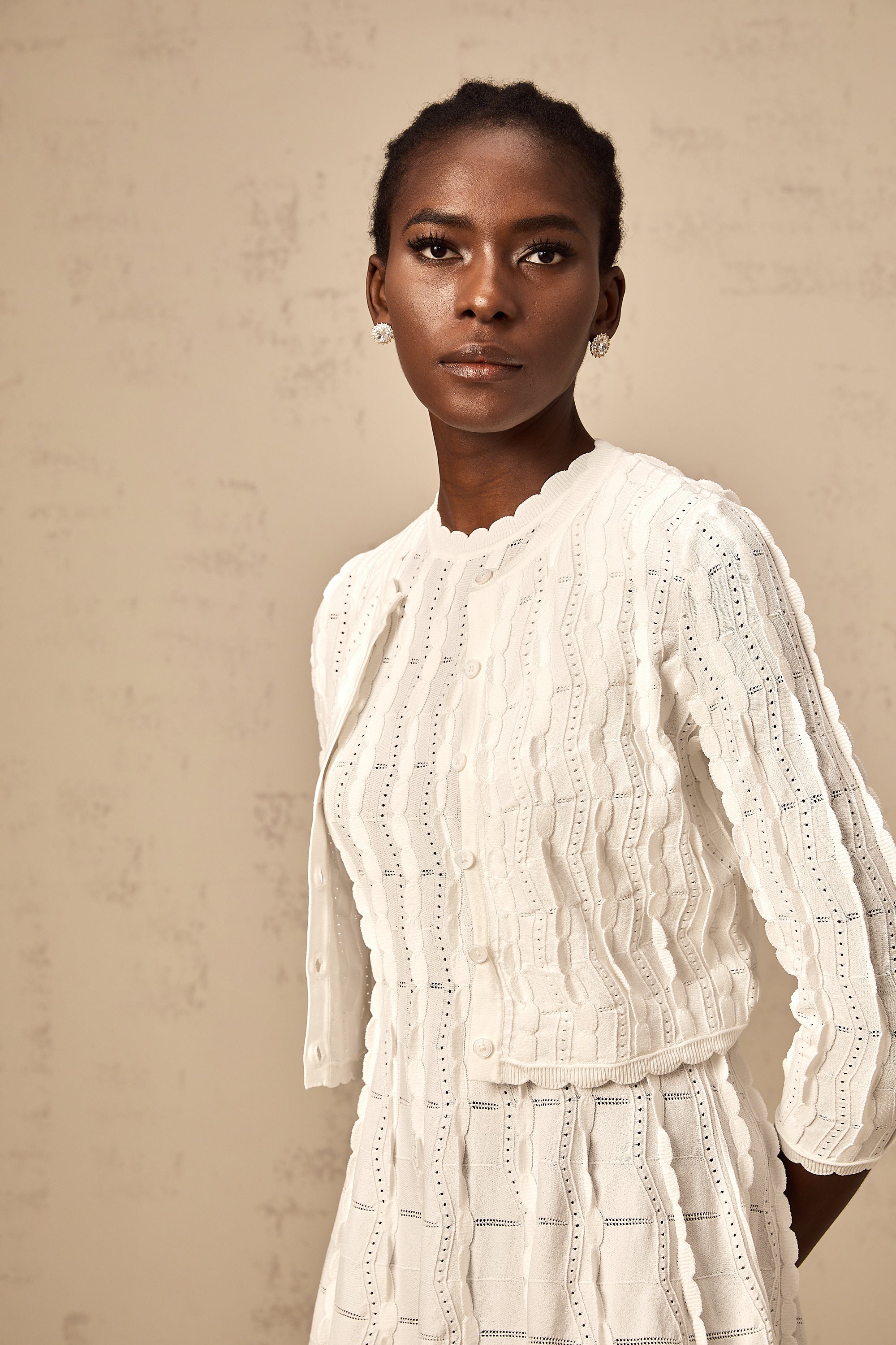 Cardigan de punto blanco Esmée con volantes, estilo rizado, de la marca Final Sale, mostrando el diseño de manga larga y detalles en la prenda.
