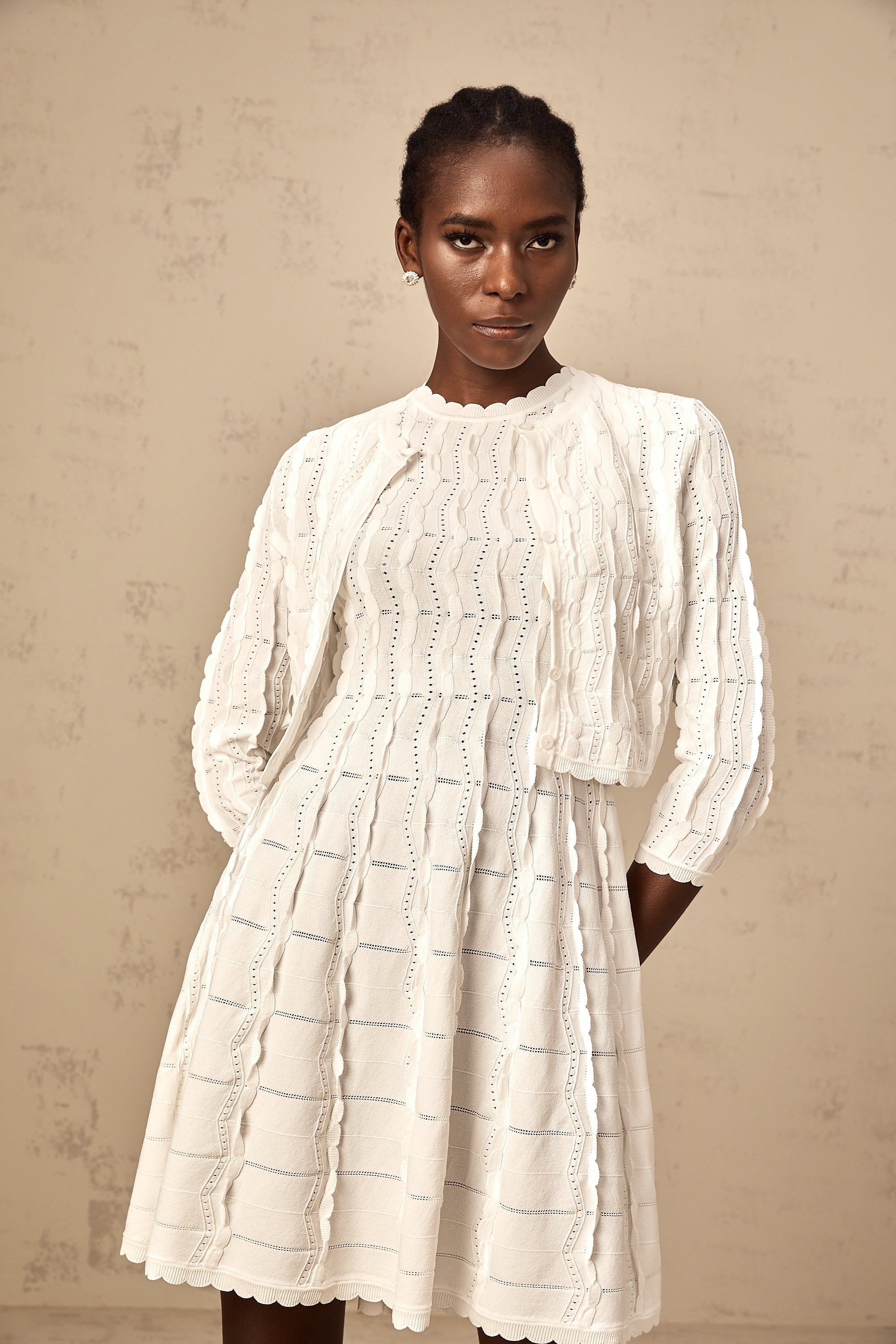 Cardigan de punto blanco Esmée con volantes, diseño de manga larga y detalles acampanados, para un estilo elegante y cómodo.