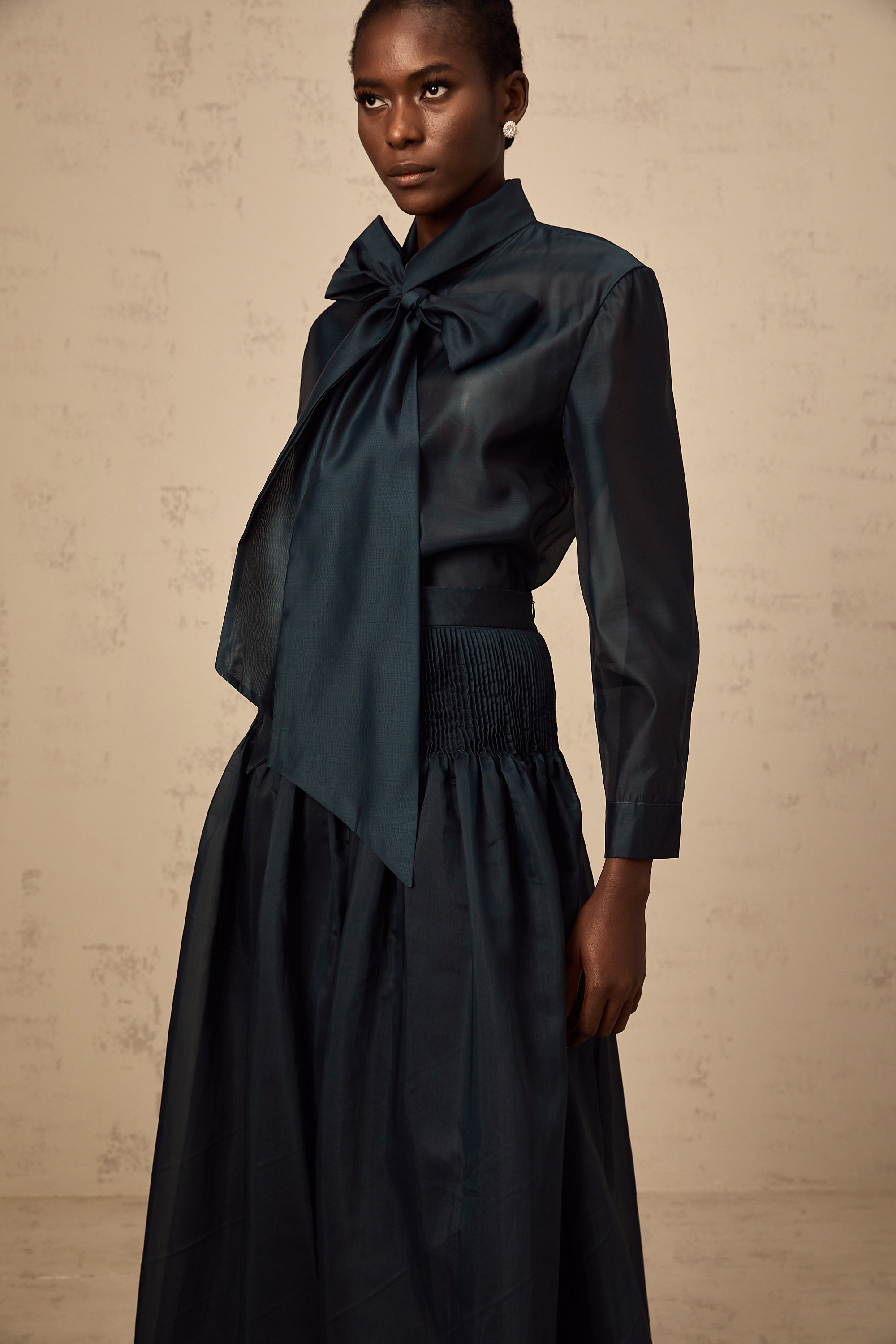 Conjunto de blusa y falda de Final Sale en verde oscuro con lazo en el cuello, diseño elegante y moderno.