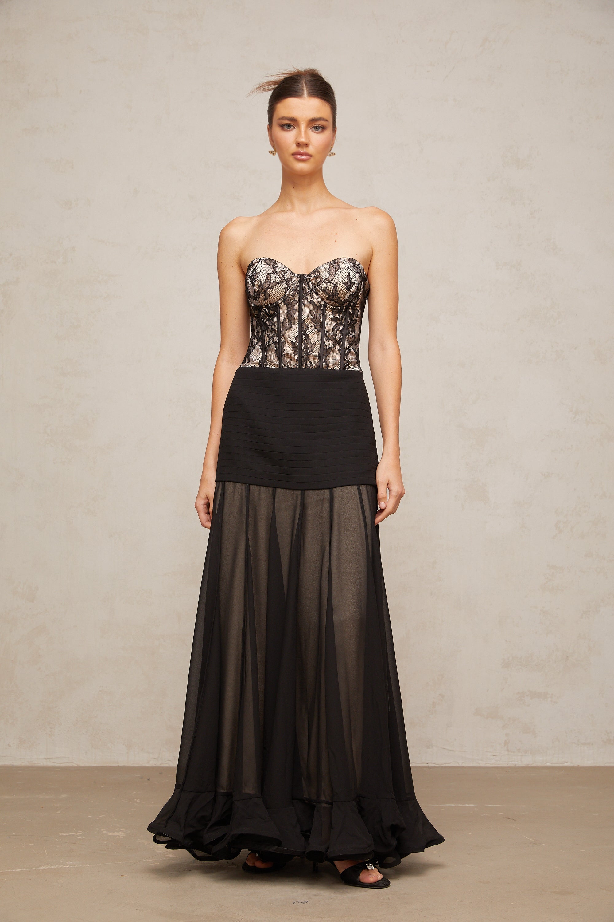 Vestido largo de encaje negro Pétunia con volante, estilo maxi y diseño elegante, ideal para ocasiones formales.