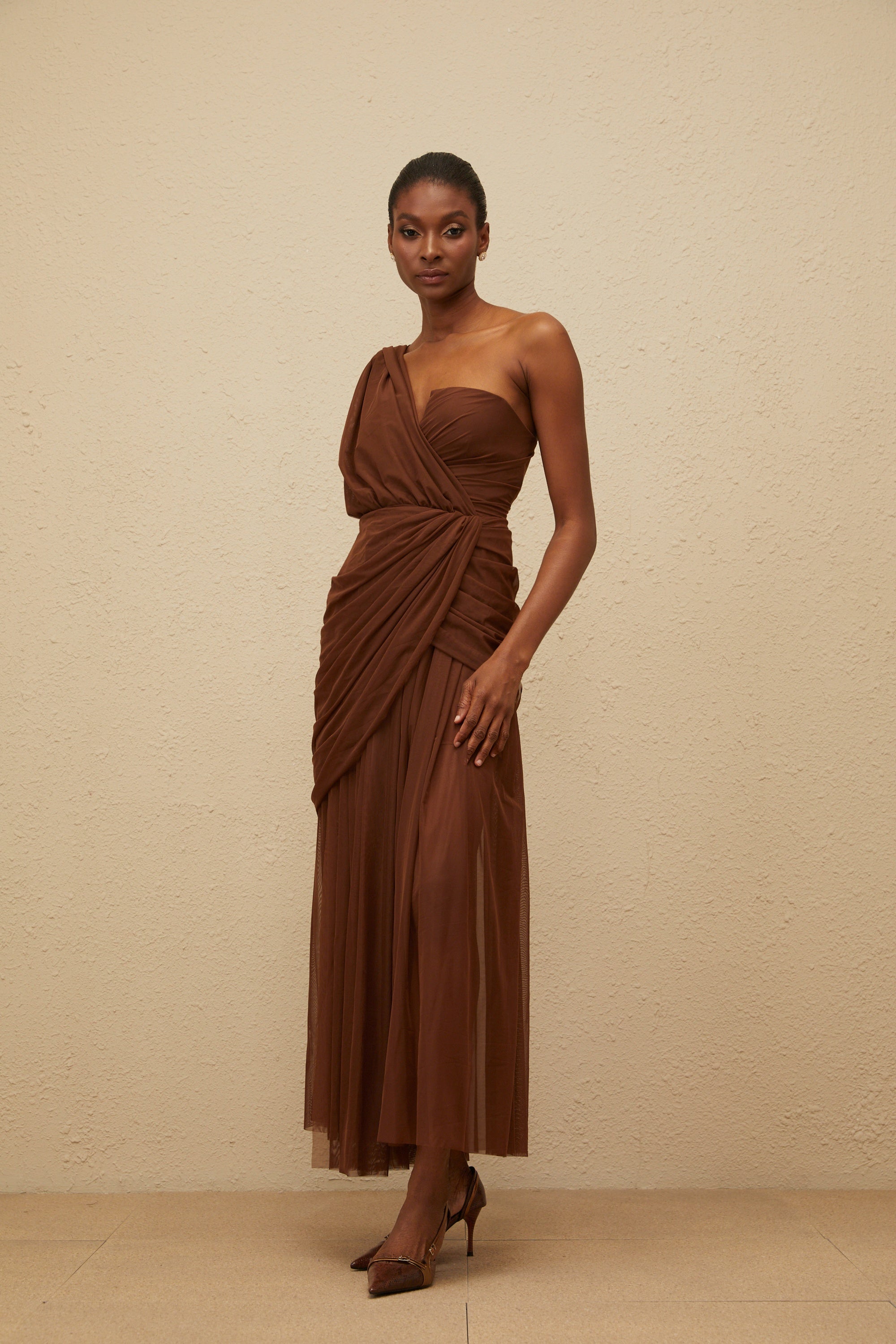 Vestido maxi de noche asimétrico en color marrón Agathe, elegante y largo, con diseño sofisticado y detalles de tela fluida.
