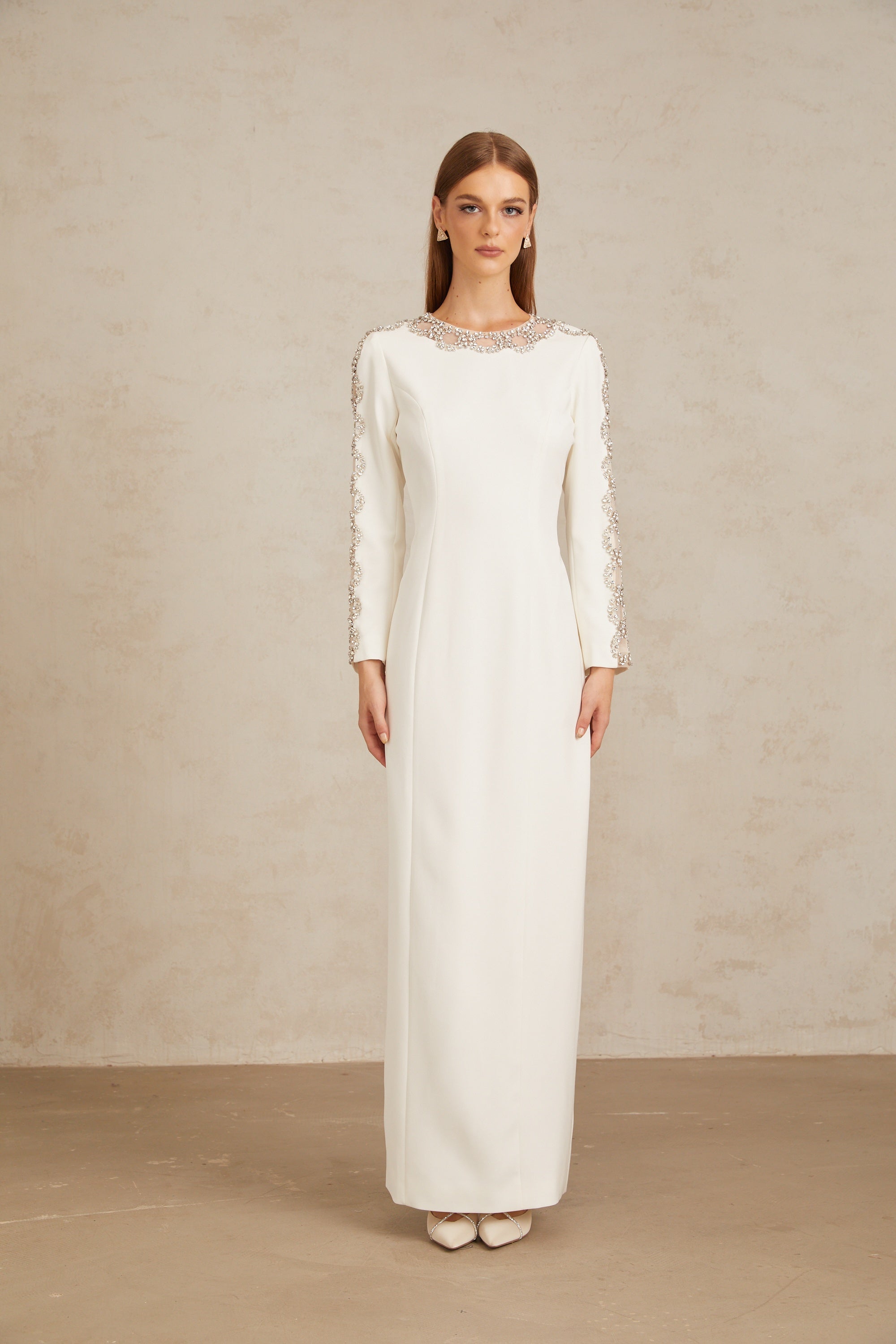 Vestido largo blanco Freja con cristales y detalles brillantes, diseñado para ocasiones elegantes y formales.