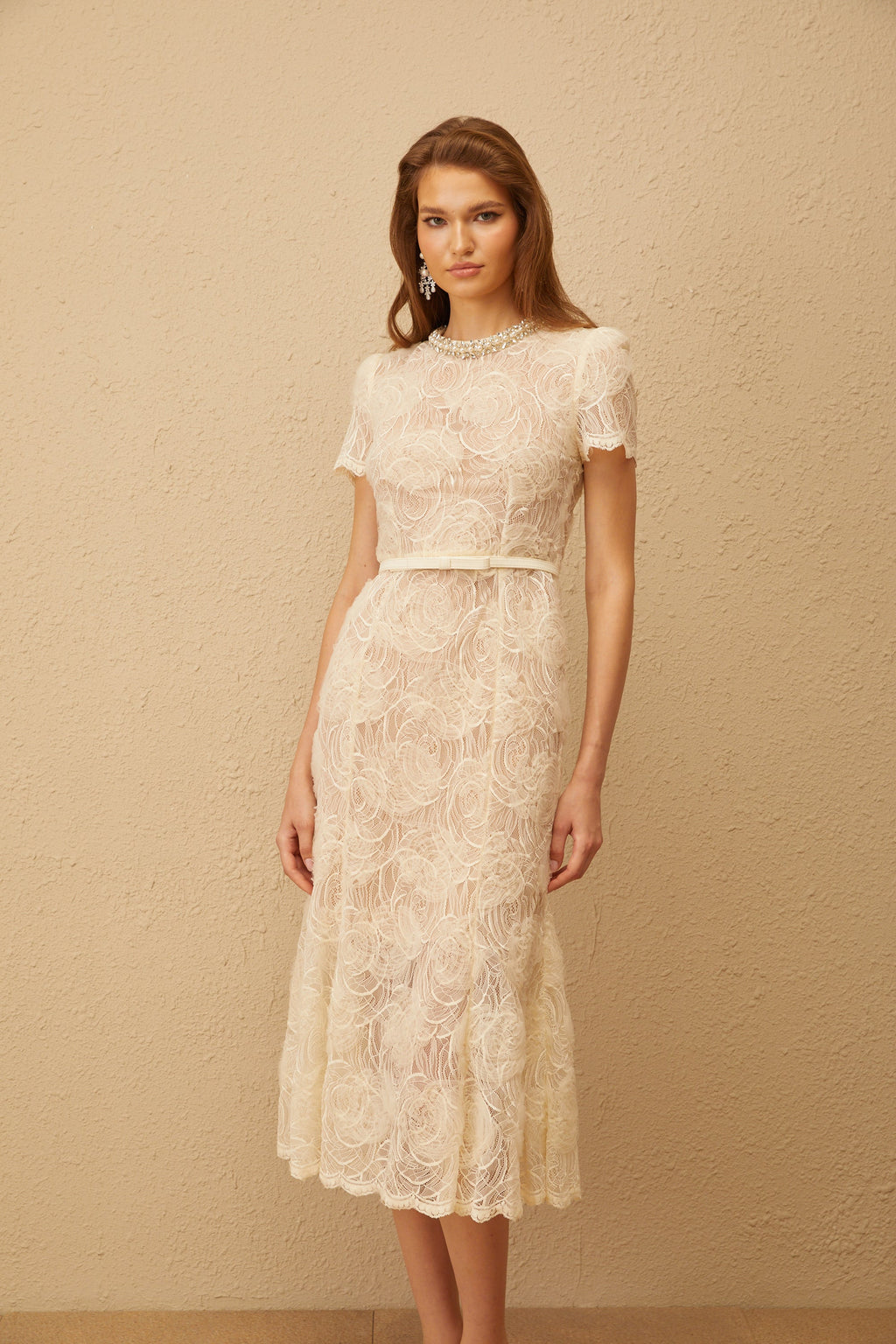 Vestido midi de encaje floral blanco Félicie con adornos, estilo elegante y femenino, en una imagen que muestra detalles de la prenda.