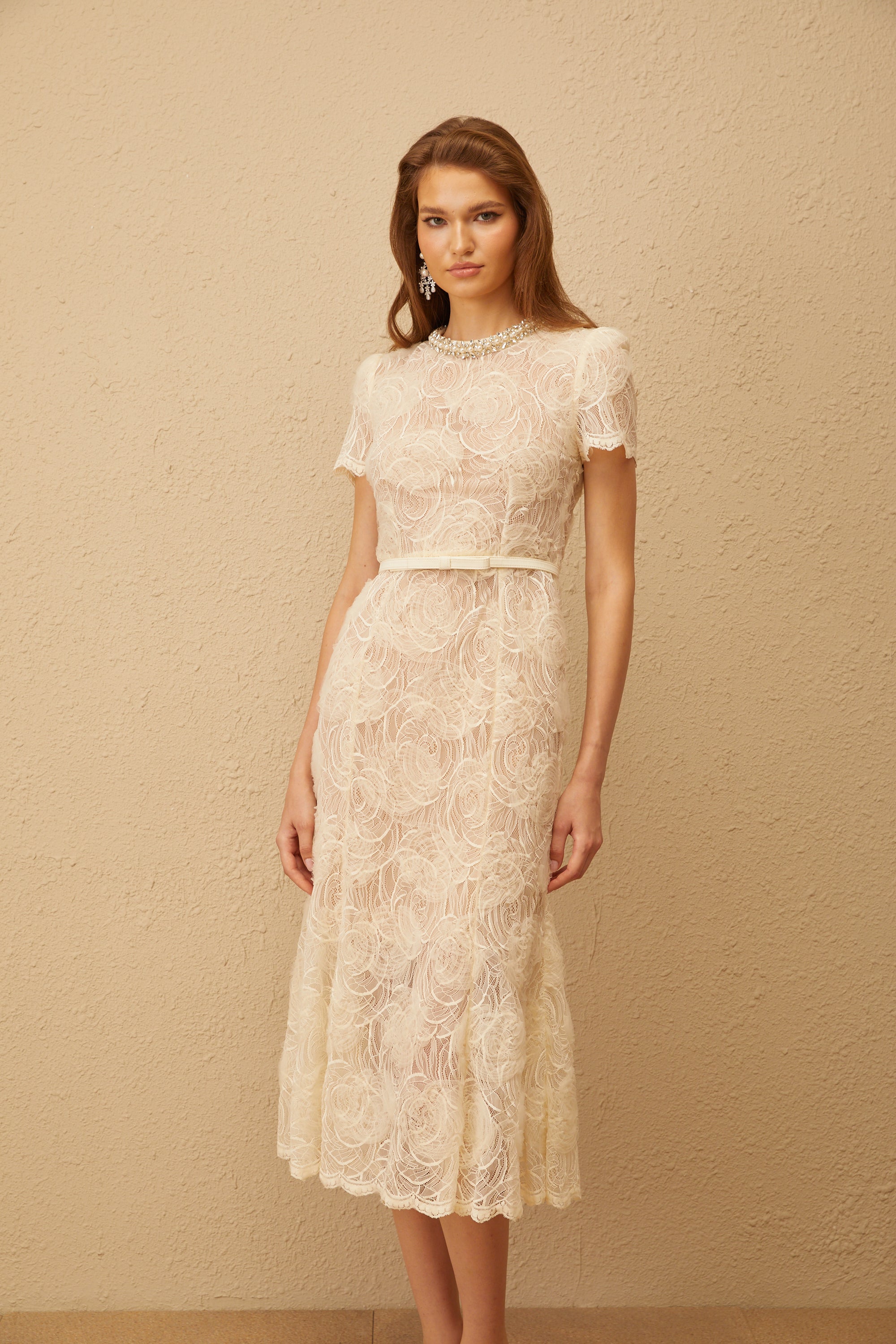 Vestido midi de encaje floral blanco Félicie con adornos, estilo elegante y femenino, en una imagen que muestra detalles de la prenda.
