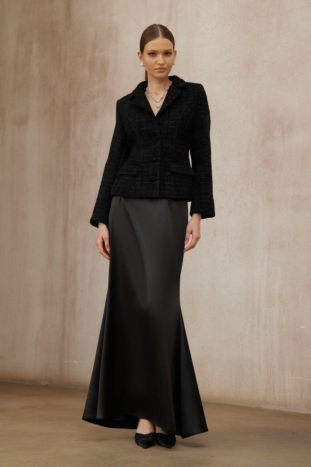 Conjunto de chaqueta de tweed negra y falda de satén de la marca Final Sale, vista en la imagen.
