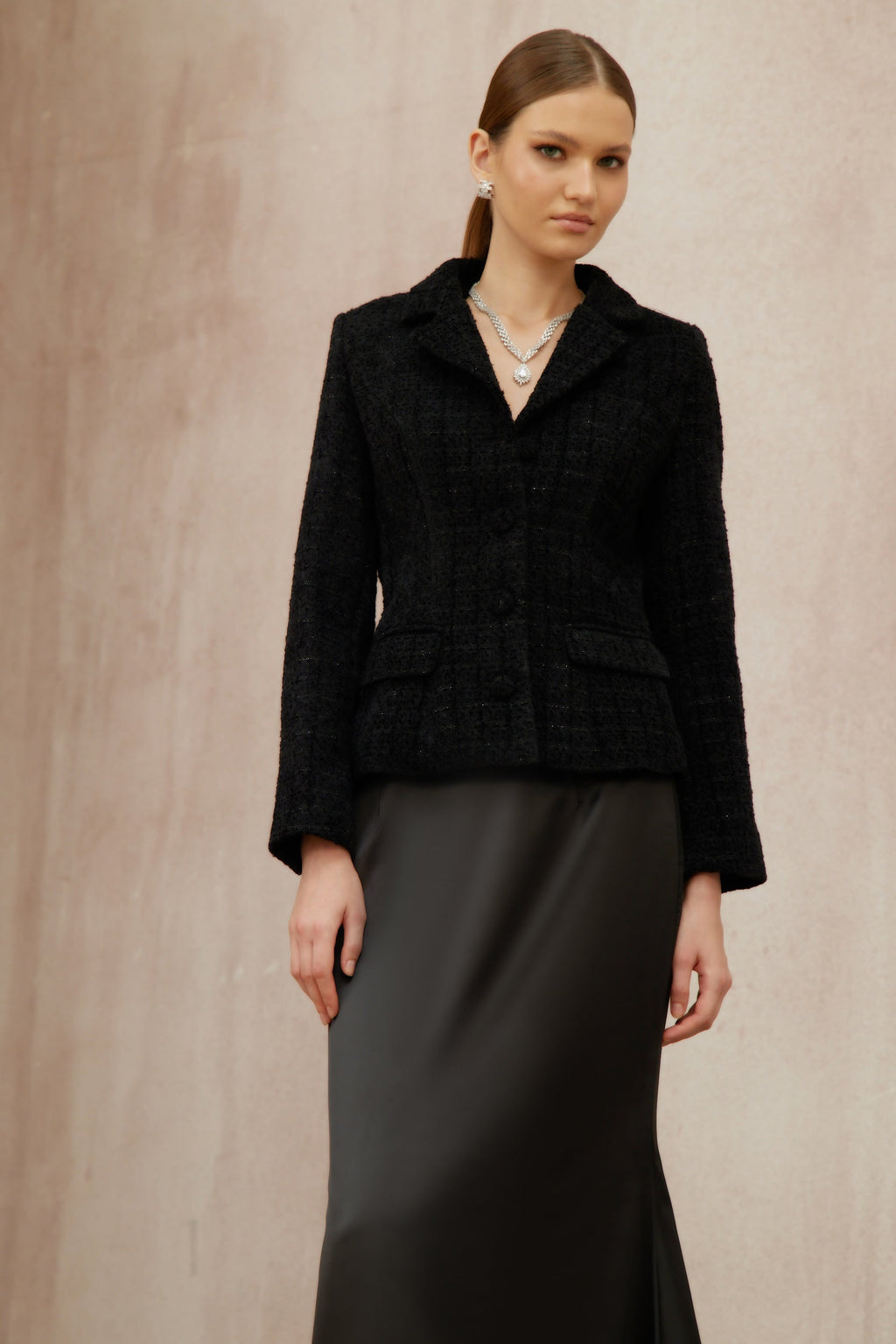 Conjunto de chaqueta de tweed negro y falda de satén de la marca Final Sale, vista en la imagen.