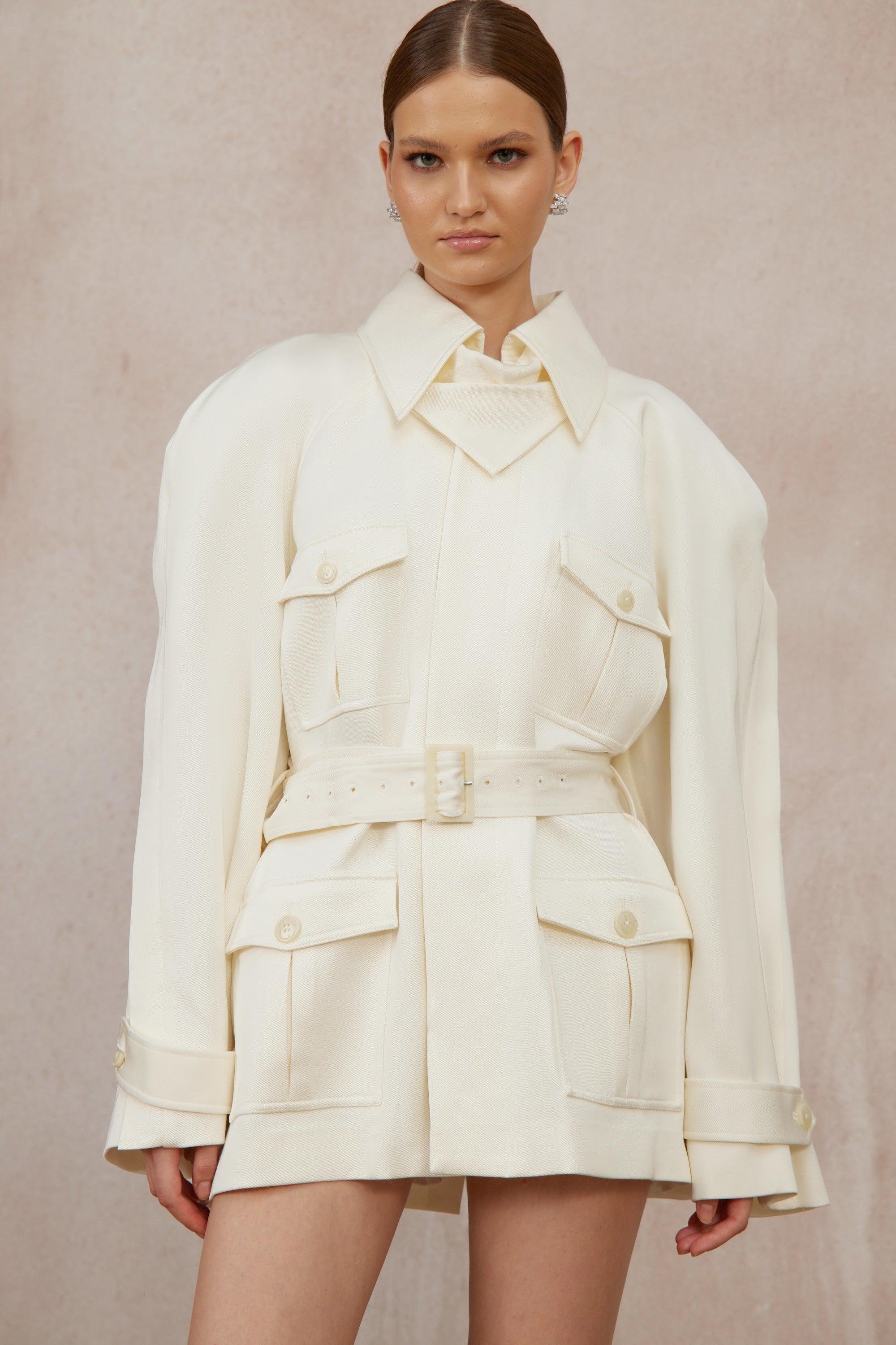 Abrigo trench blanco con cinturón de marca Final Sale, estilo clásico y elegante, visible en la imagen.