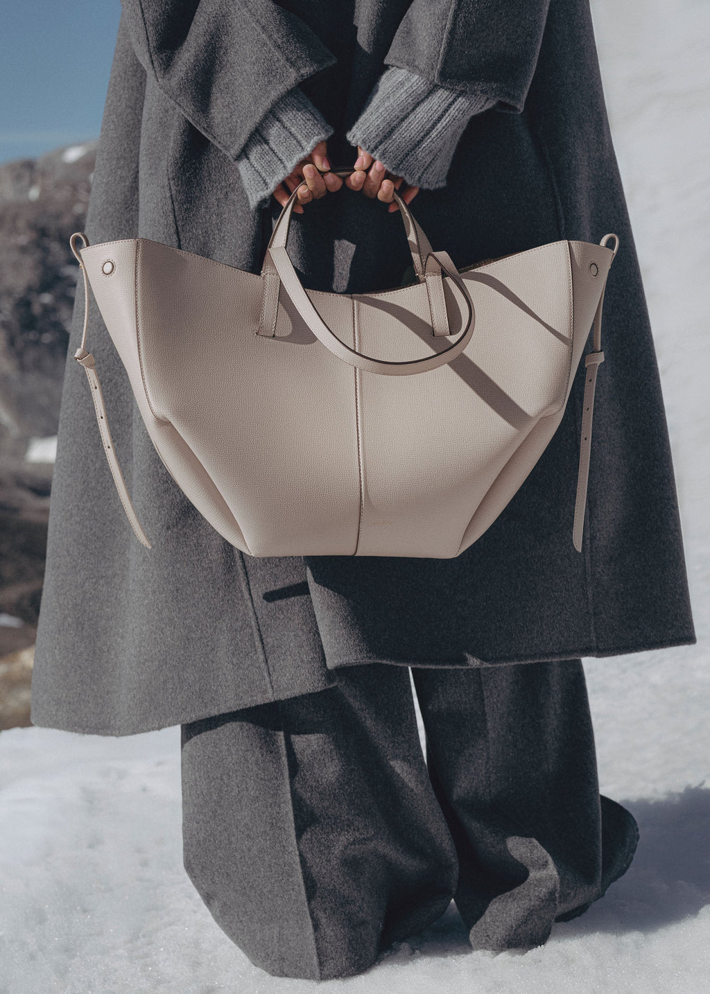 Bolso de mano Polène Cyme con piel granulada en diseño elegante y detalles sofisticados.