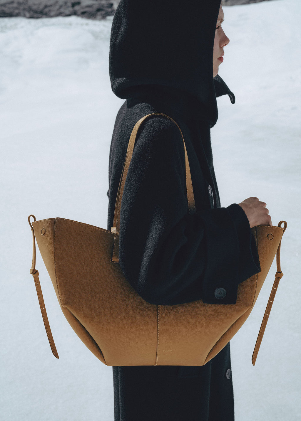 Bolso de mano Polène Cyme en piel ocre granulada, con diseño elegante y detalles en textura de piel granulado.