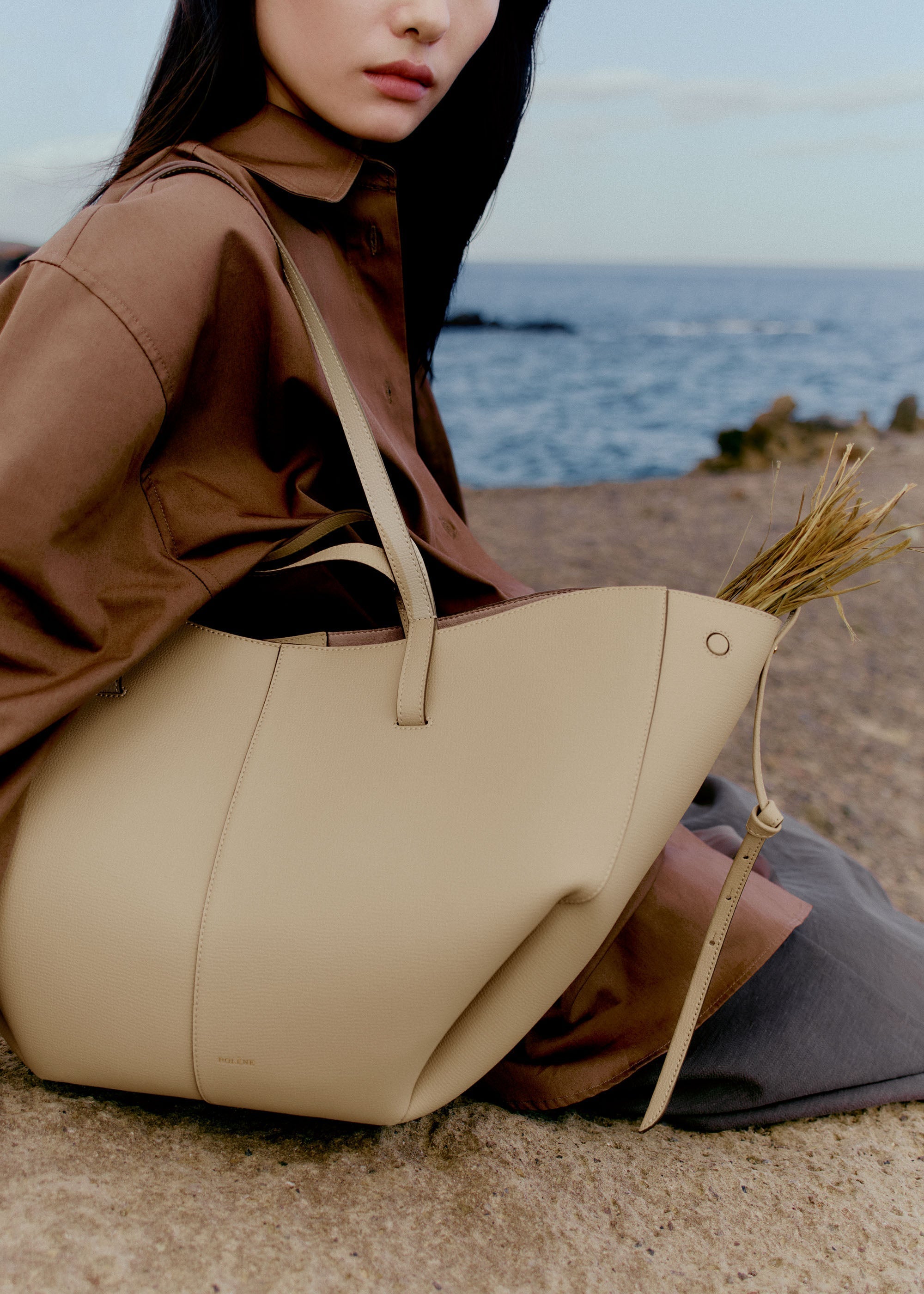 Bolso de mano Polène Cyme Arena Piel Granulada con asa superior y diseño elegante, detalles en piel texturizada.