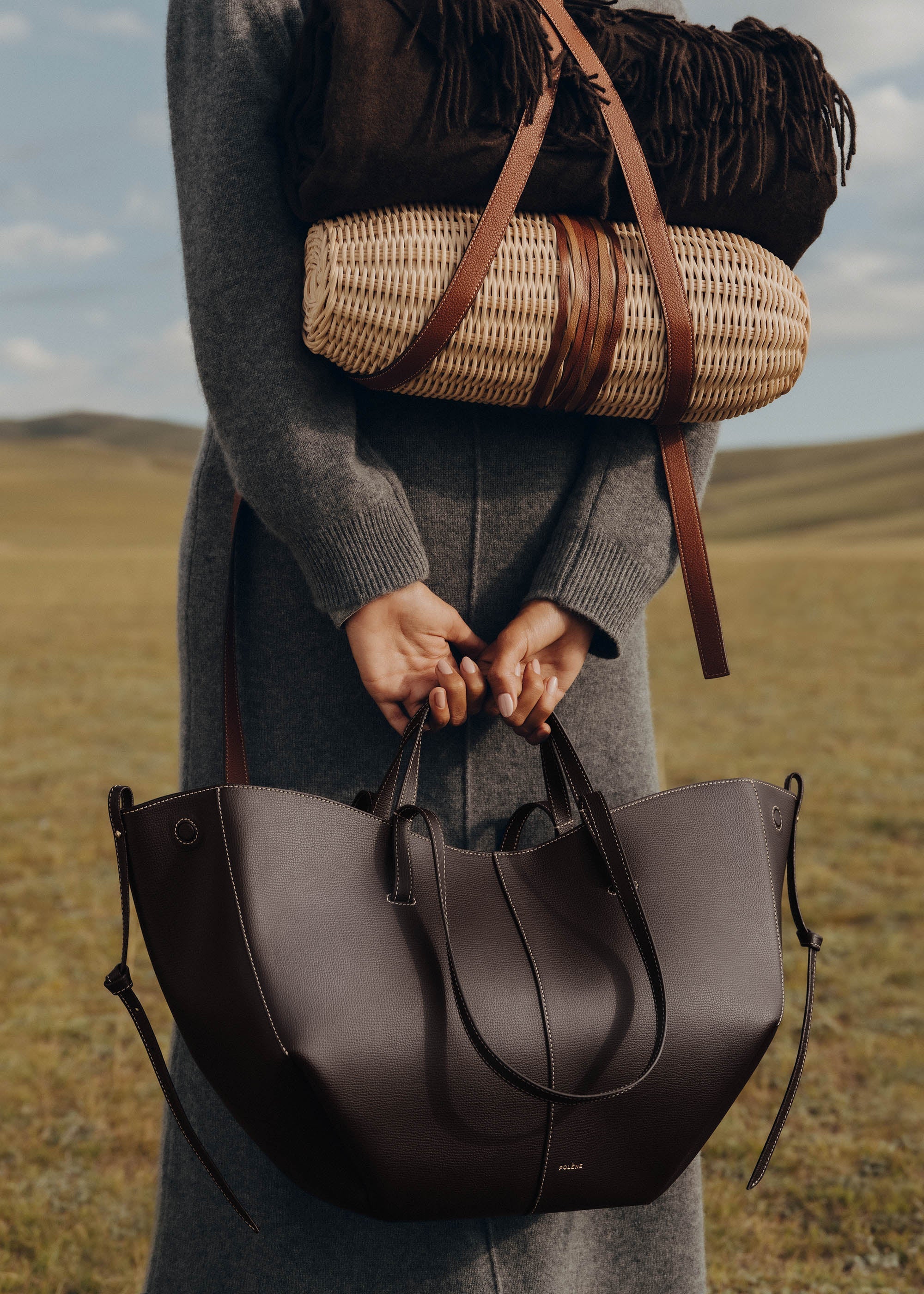 Bolso de mano Polène Cyme en piel de ébano con textura granulada y detalles de sobrecostura en la superficie.