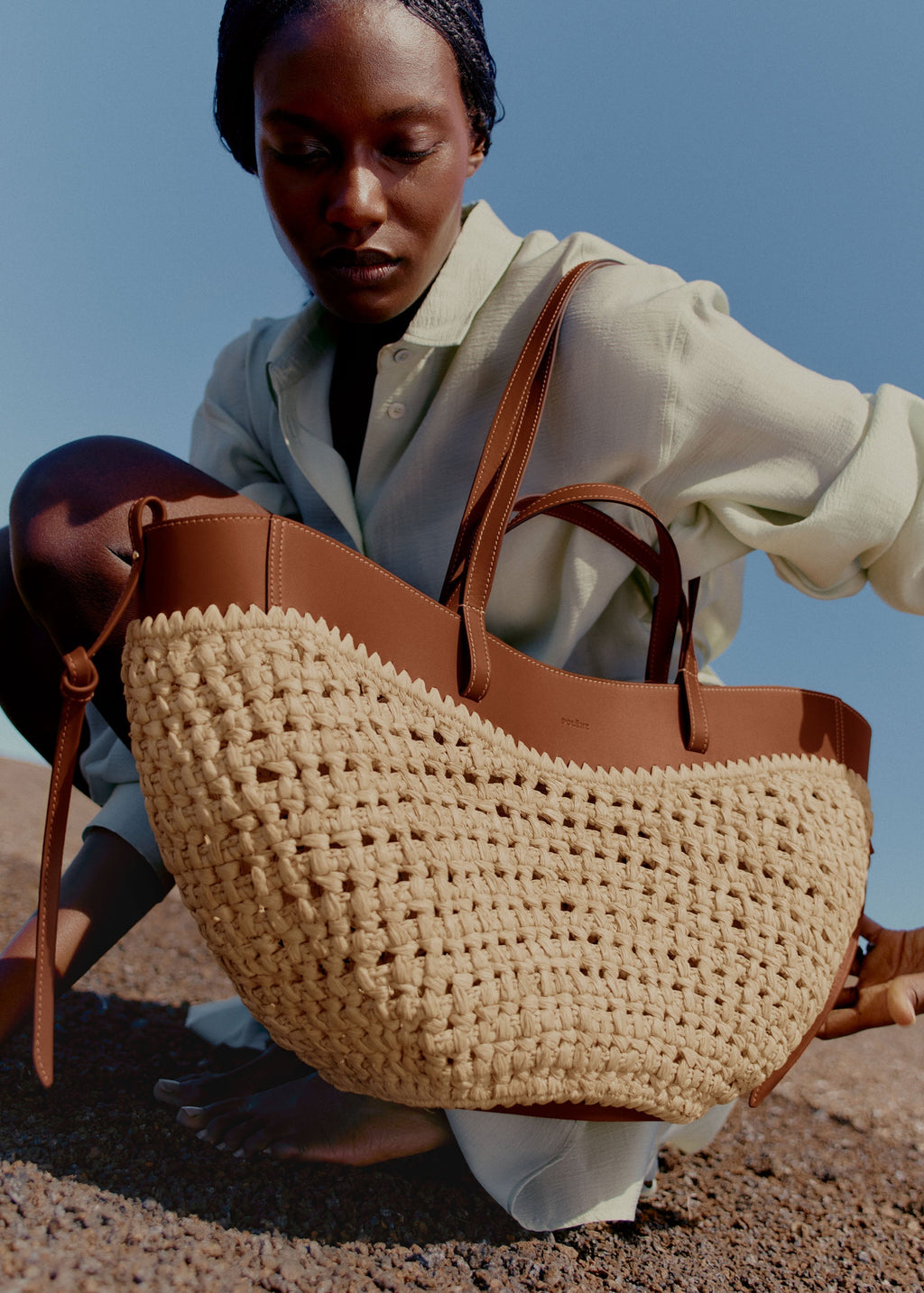 Bolso de mano Polène Cyme en rafia, con asas cortas y diseño elegante.