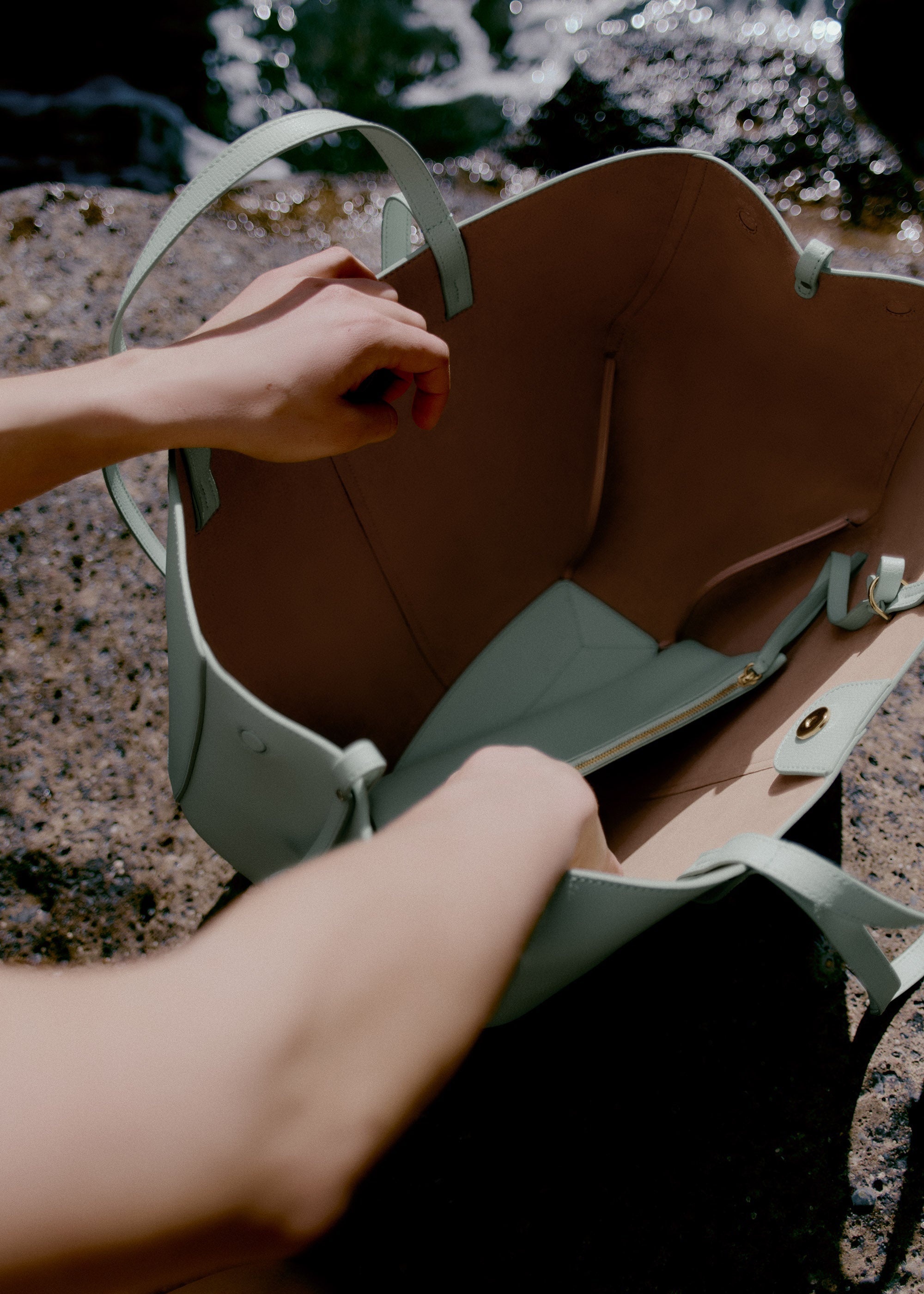 Bolso de mano Polène Cyme en espuma de piel granulada, con detalles elegantes y texturizados en color neutro.