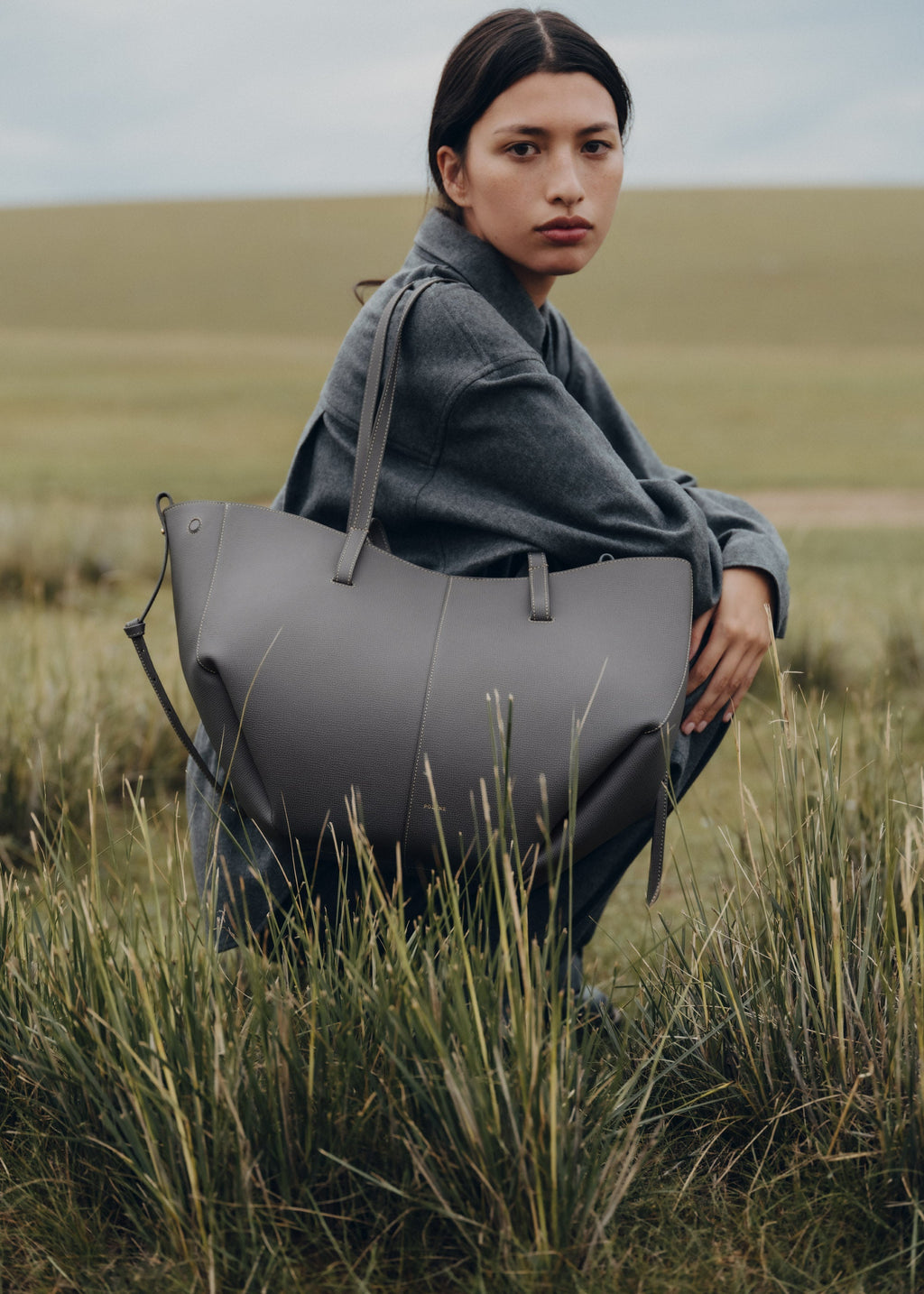 Bolso de mano Cyme de Polène en piel granulada con detalles de piedra, diseño elegante y moderno.