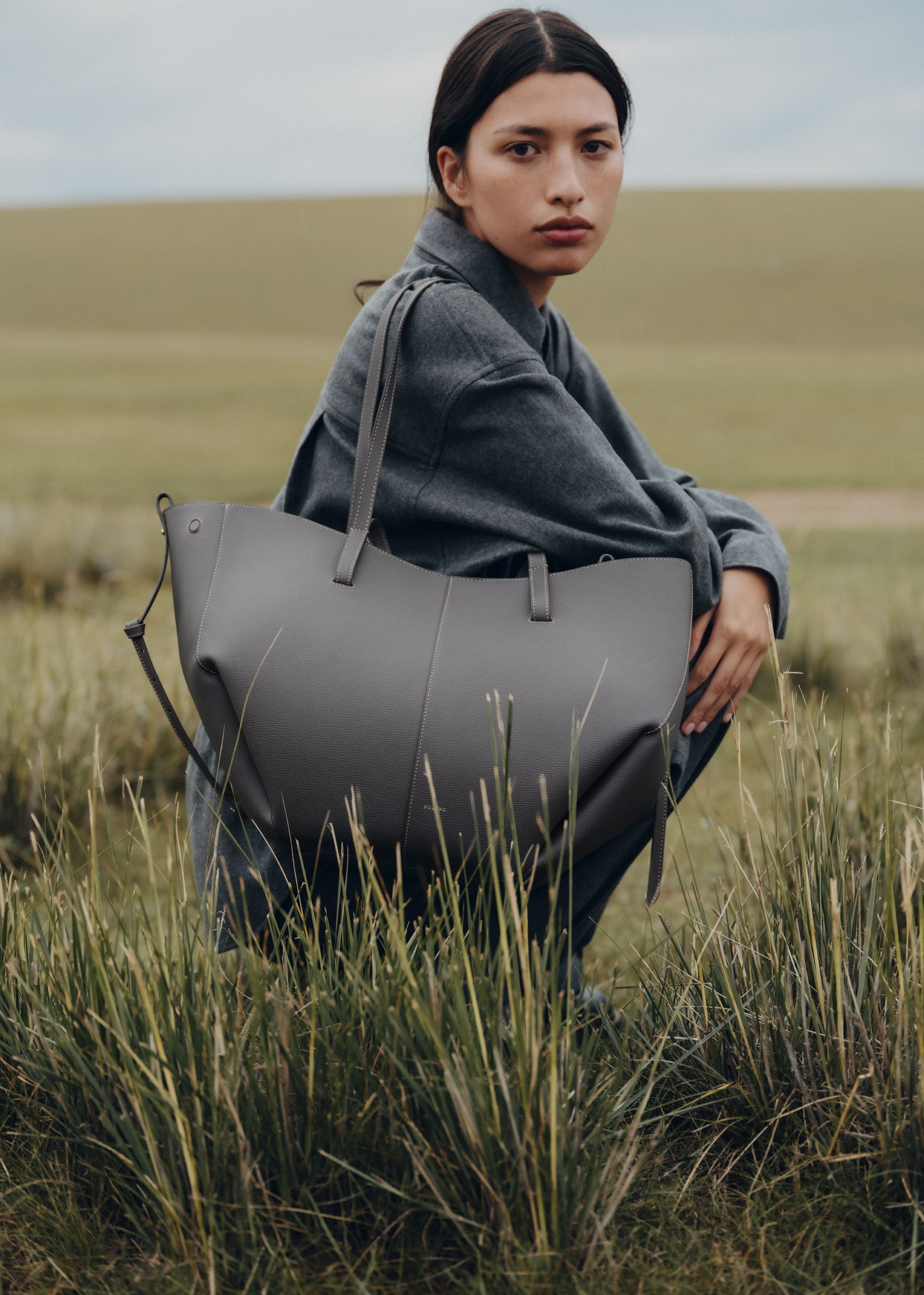 Bolso de mano Cyme de Polène en piel granulada con detalles de piedra, diseño elegante y moderno.