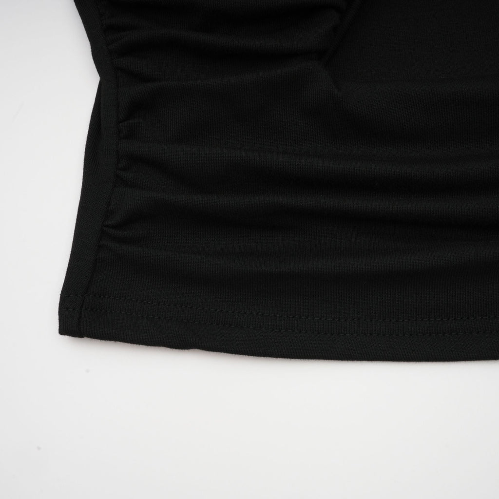 Blusa negra Anaïs con abertura frontal y detalles fruncidos, vista frontal, estilo elegante y moderno.