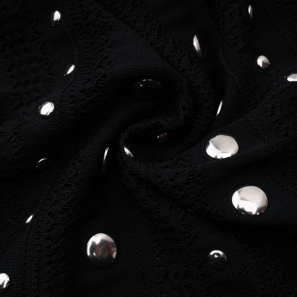 Vestido midi de encaje y punto con manga larga y tachuelas negras de Bridal, diseñado por Chloé, visible en la imagen.