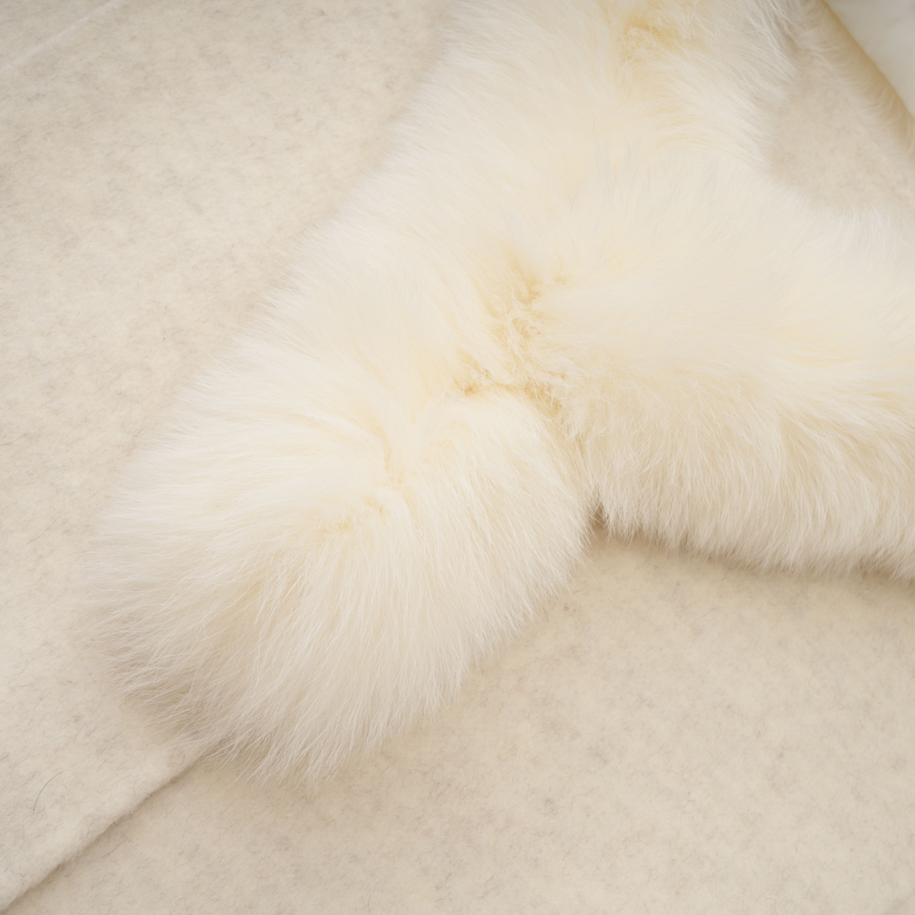 Abrigo blanco con cinturón y borde de piel, marca Bridal, vista frontal que muestra su diseño elegante y detalles en la textura.