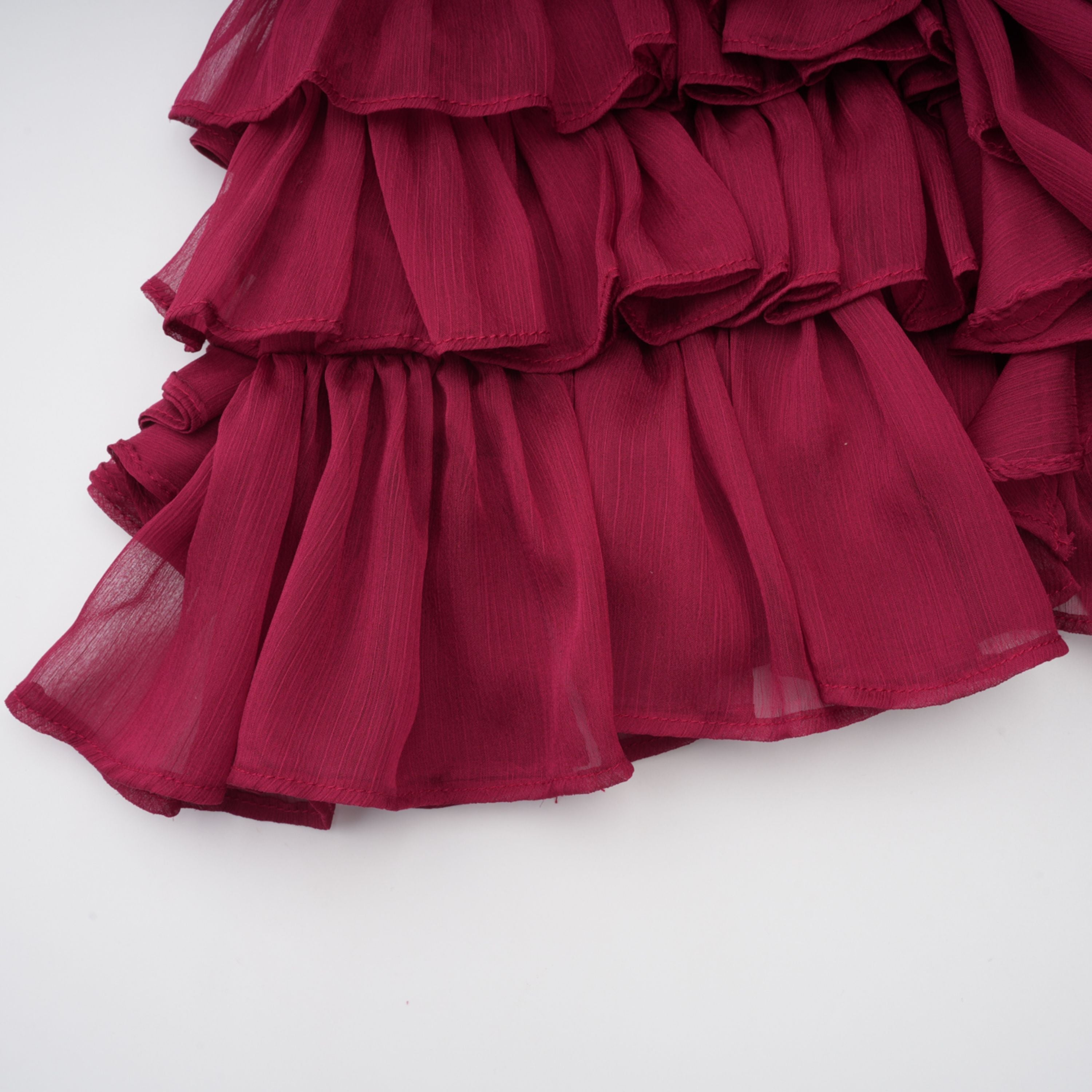 Vestido mini asimétrico de tul con volantes en color burdeos Éléna de Final Sale, mostrando su diseño elegante y detalles ruffle
