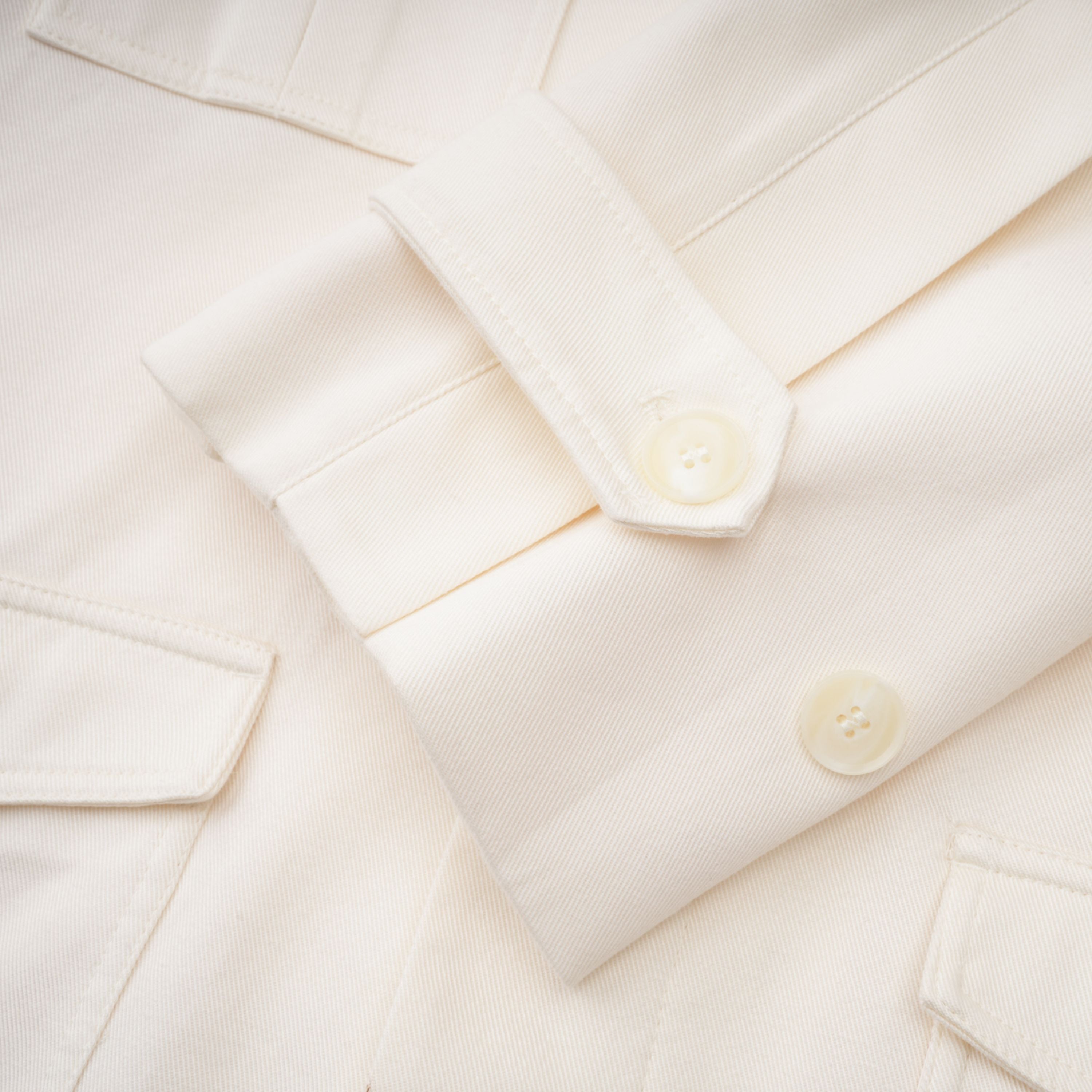 Abrigo trench blanco con cinturón de la marca Final Sale, estilo clásico y elegante, en color crema y largo hasta la rodilla.