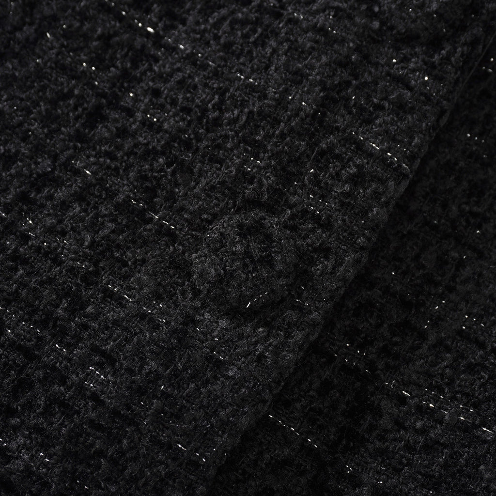Conjunto de chaqueta negra de tweed y falda de satén de la marca Final Sale, vista en la imagen.