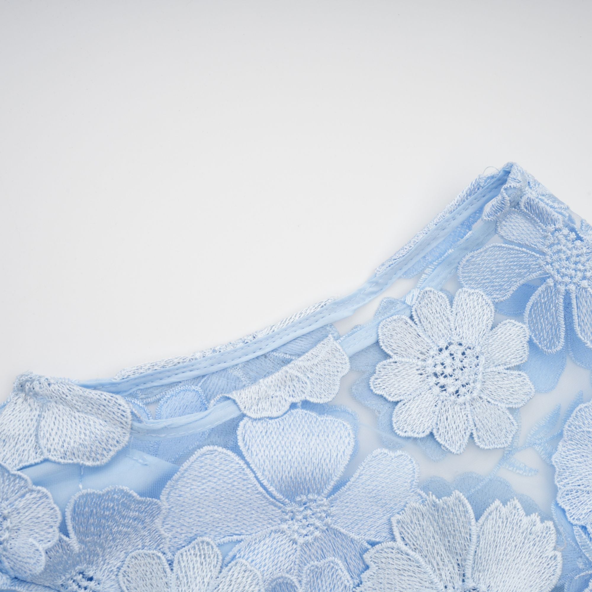 Vestido midi azul con apliques florales de Herta, estilo elegante y femenino, con detalles delicados en la tela.