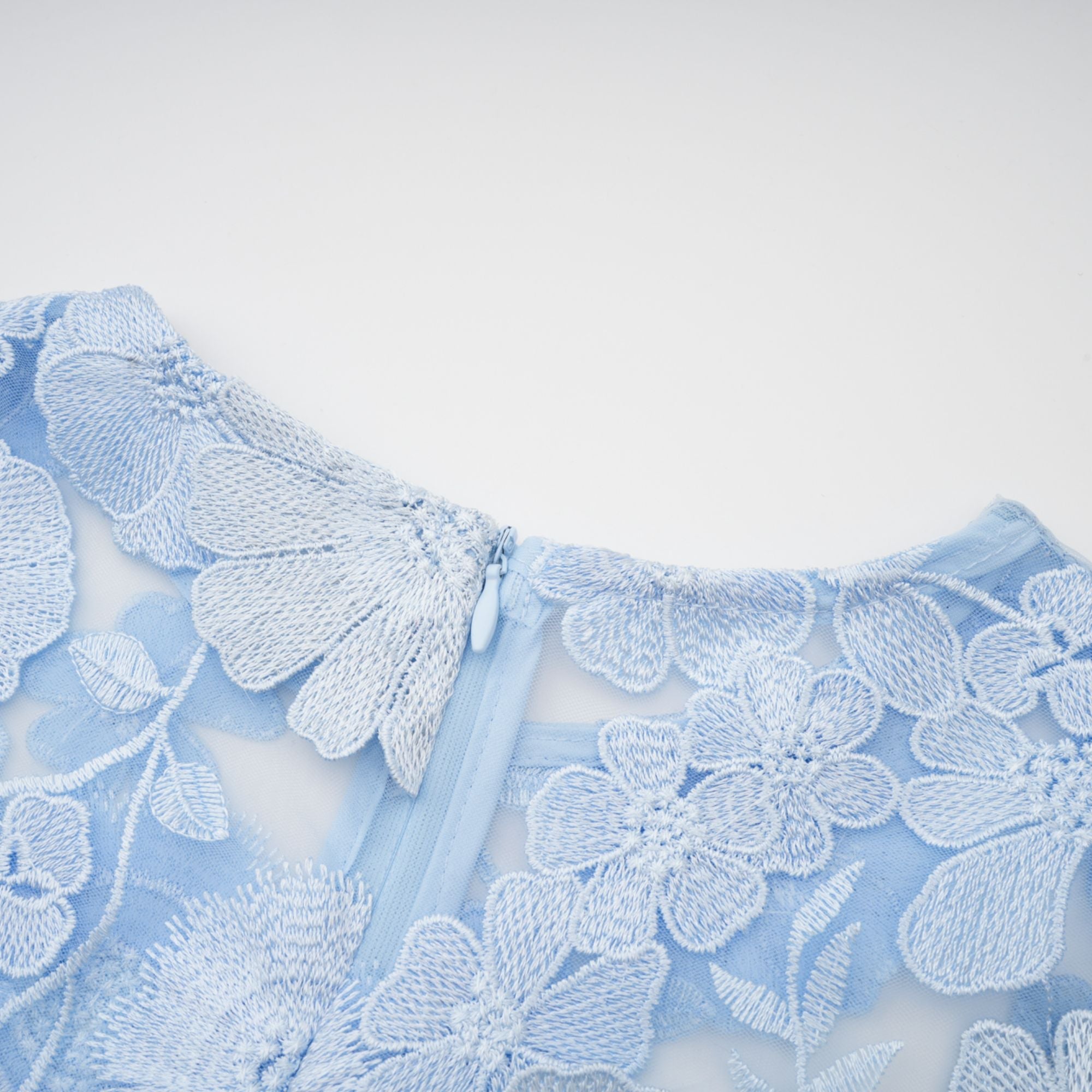 Vestido midi azul con bordado floral de Herta, diseño elegante y moderno, con detalles de appliqué y escote en V.