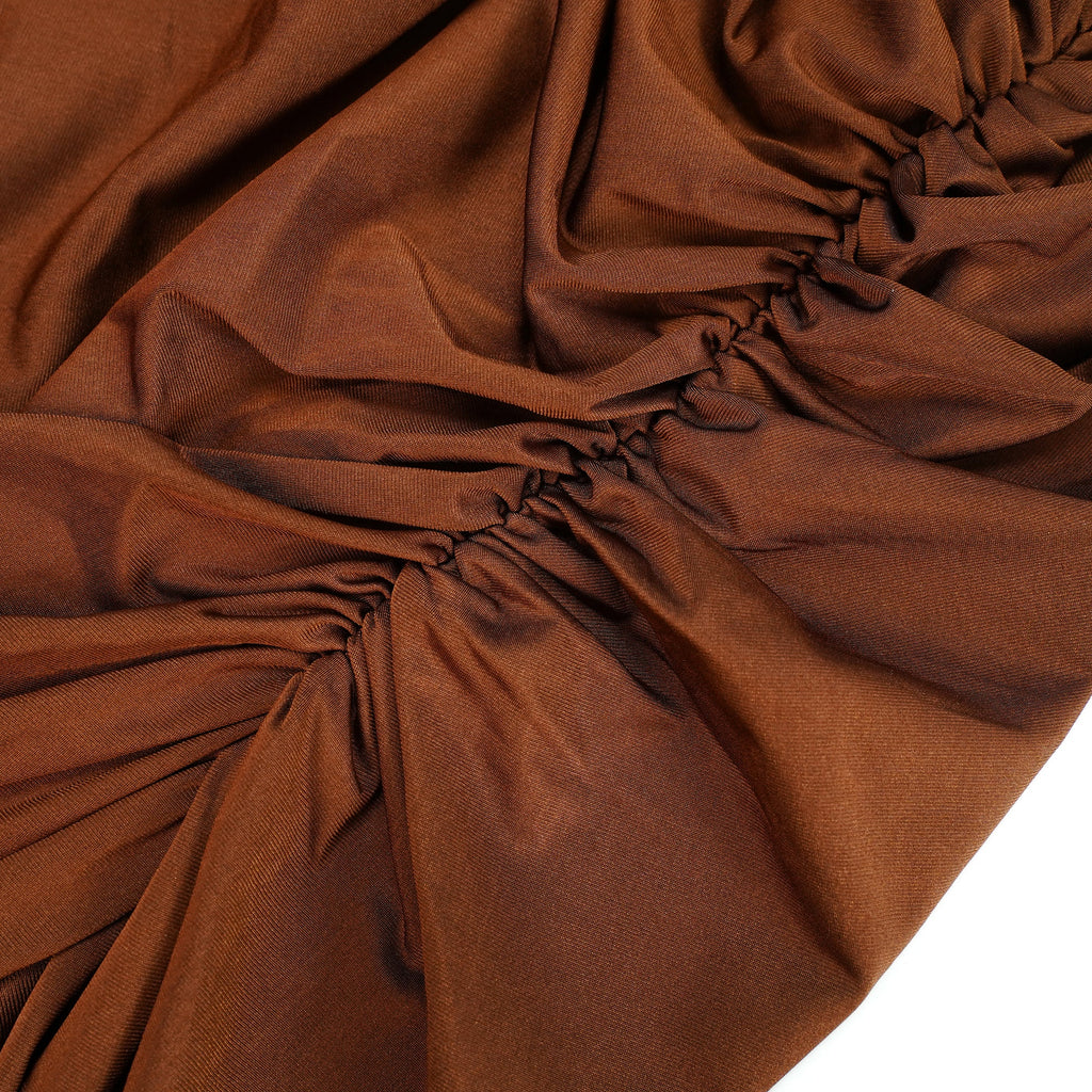Vestido largo asimétrico Reine Brown con fruncido, estilo maxi, en color marrón, mostrado en una fotografía con fondo neutro.